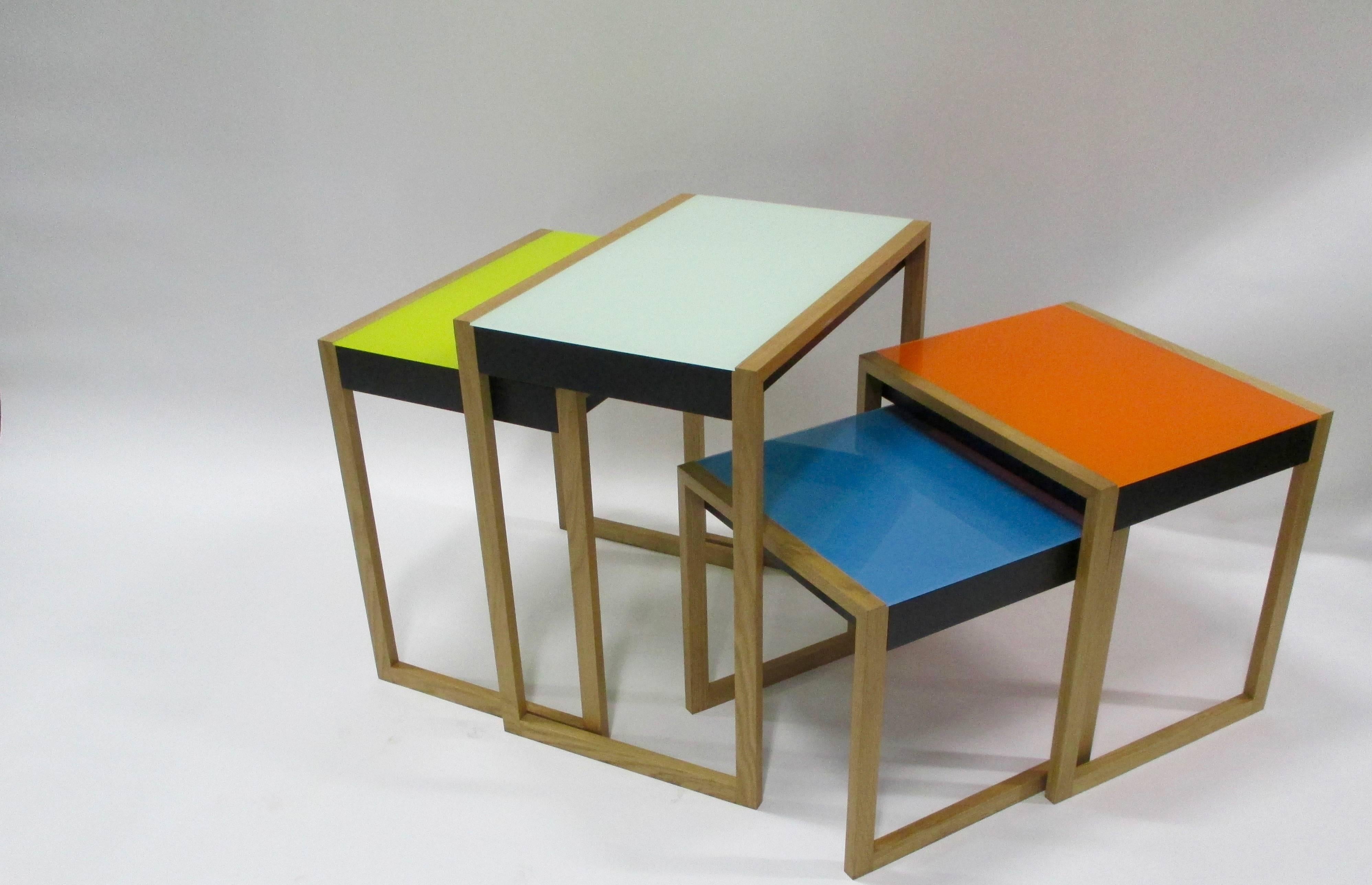 Four stacking side tables by Josef Albers with solid oak frames and lacquered tops with black lacquered aprons.