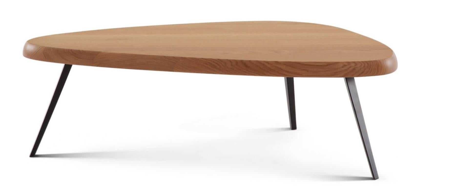 Low table by Charlotte Perriand. Black matte finished metal legs, triangle shaped top with rounded edges. Top in natural oak.