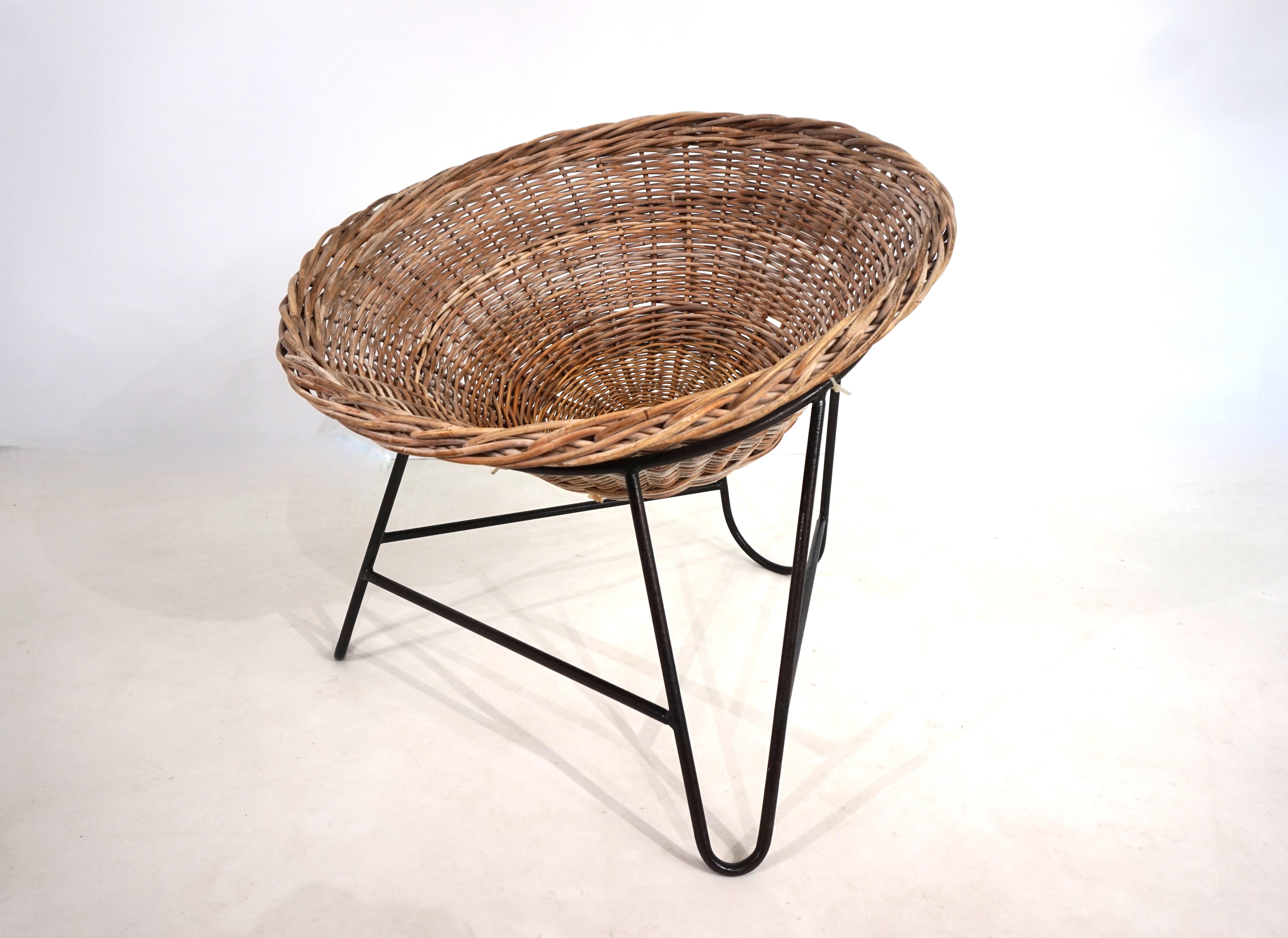 Cette chaise en rotin est en bon état. La vannerie est intacte et solide. Le cadre en métal recouvert de plastique noir présente quelques écailles du revêtement plastique et des signes d'usure. Les chaises ont acquis une belle patine au fil des ans.