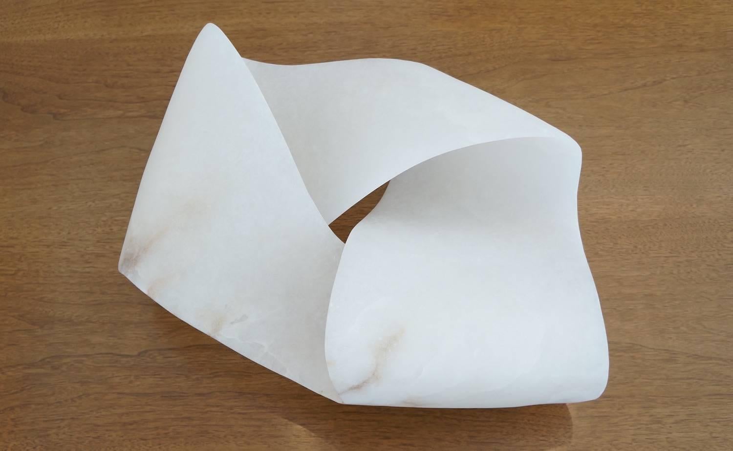 Hand-carved alabaster sculpture. An extraordinary piece, based on a Mobius strip, which has one edge and one surface. The alabaster, from Volterra, Tuscany, is stunning, both in scale and translucency. 