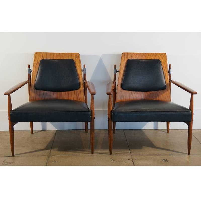 Pair of Mid-Century red elm upholstered armchairs with bent plywood backs and aluminium stretcher. Original black leatherette with tied springs.
 