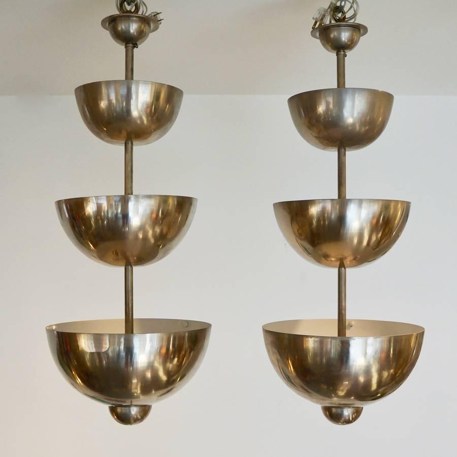 Aluminum half sphere spun and polished dome pendants. Three-tiered, two sockets per. Priced individually.