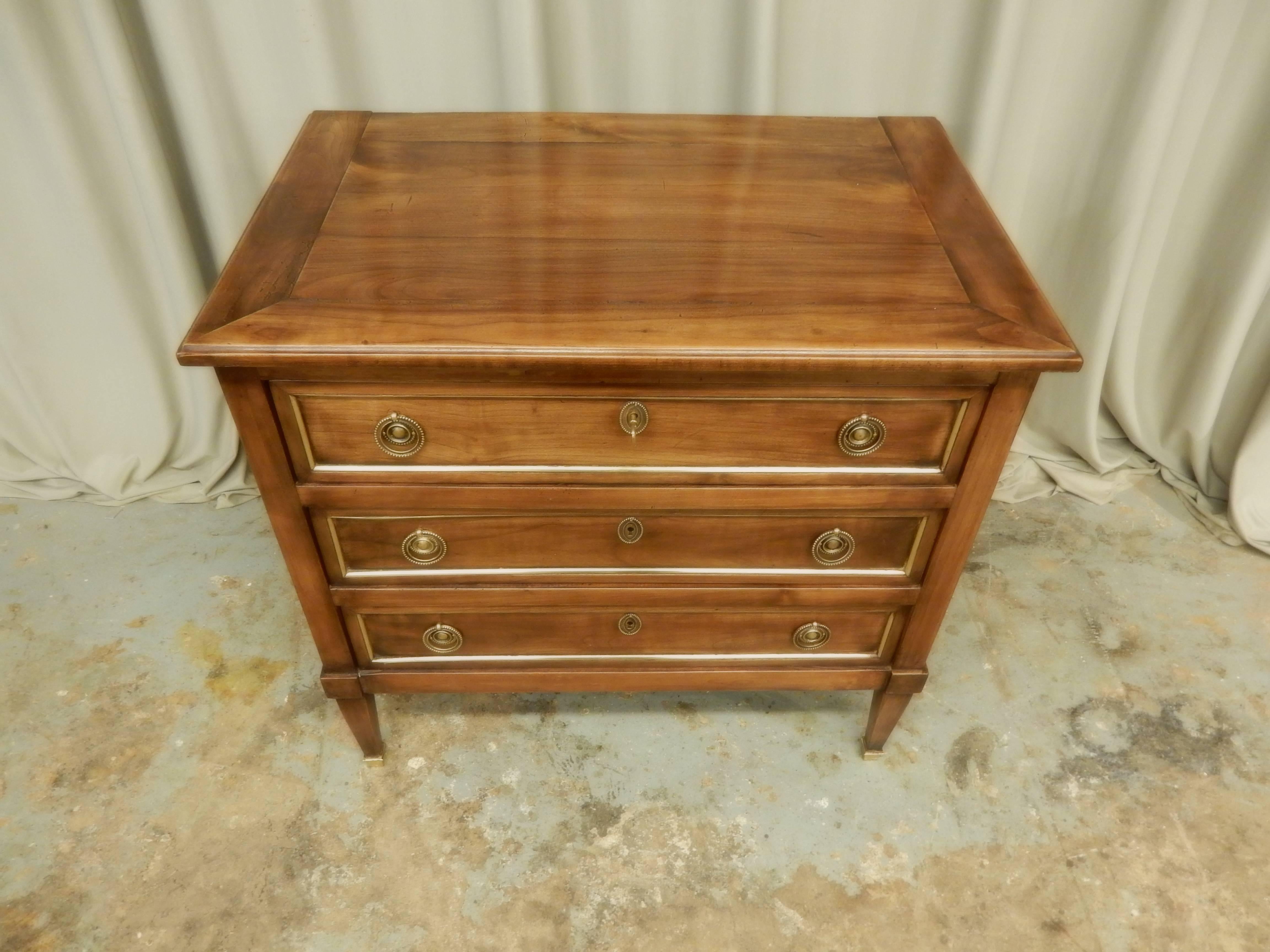 Small brass trimmed three-drawer French Louis XVI walnut 19th century commode.