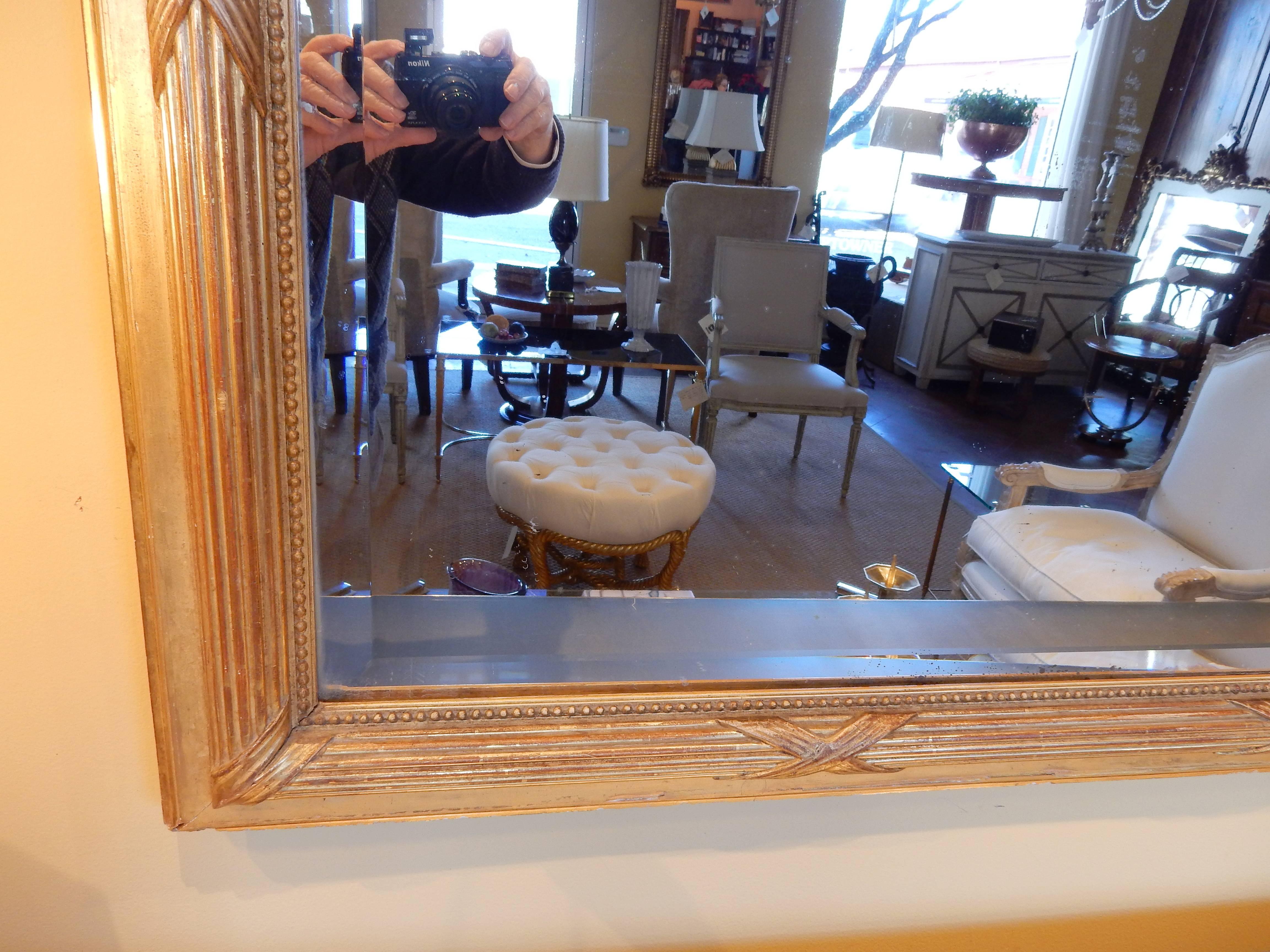 Beautiful gold gilt French 19th century Louis XVI style gilt mirror with original beveled mirror.