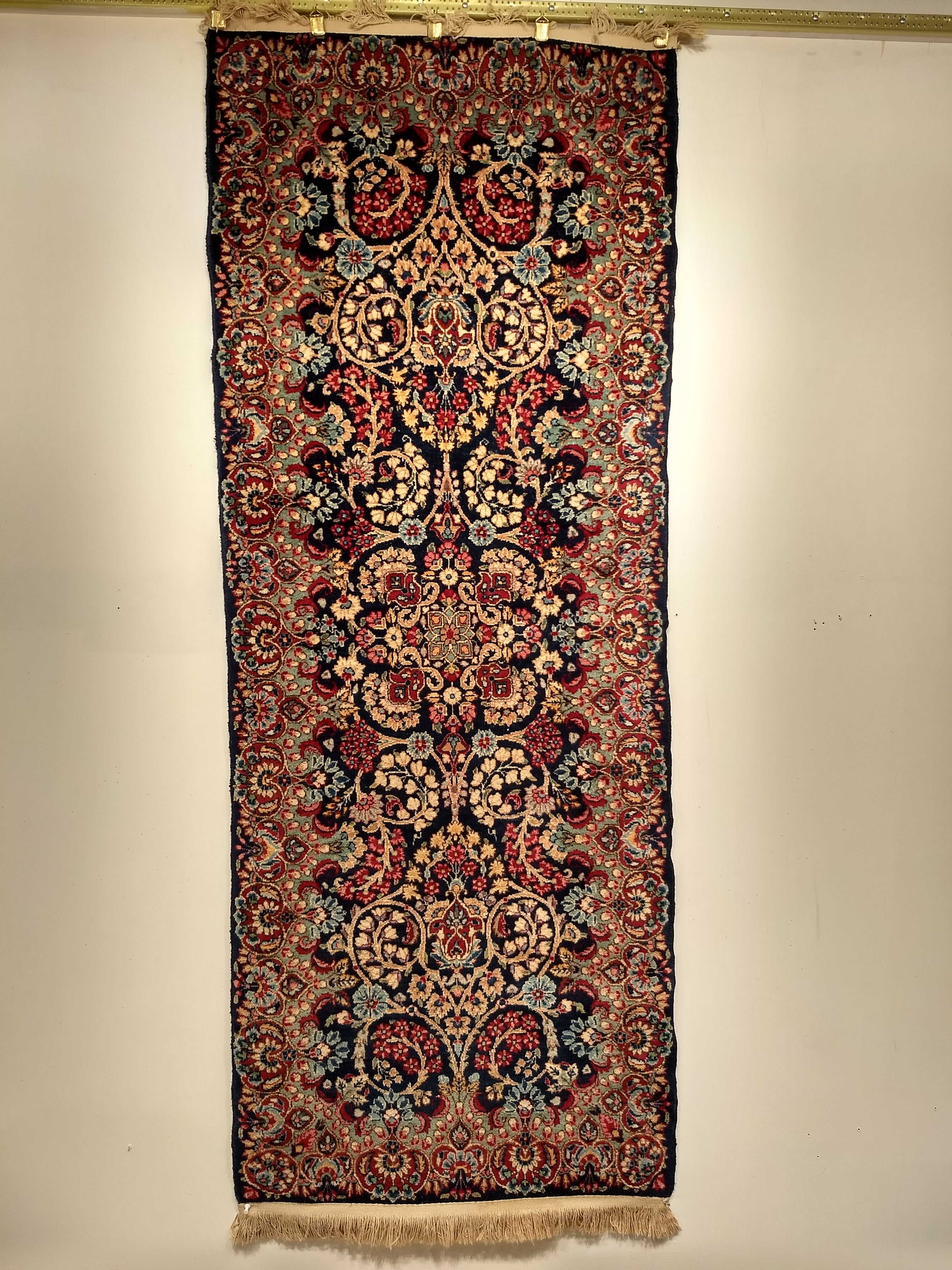 A beautiful vintage Persian Kerman runner or area rug with an all-over floral pattern from the early 1900s.  The rug has a navy blue field color with floral designs in green, baby blue, ivory, and red.
Dimensions:  2′ 6″ x 6′ 6″
Date of Manufacture: