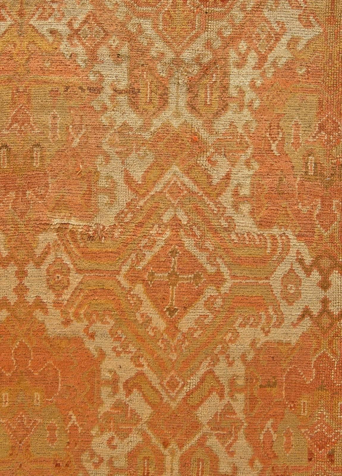 A late 19th century Turkish Oushak (Ushak) antique rug the rose hooked device trellis with enlarged serrated pendants overall within the pale blue field within a gold rosette and leafy border.