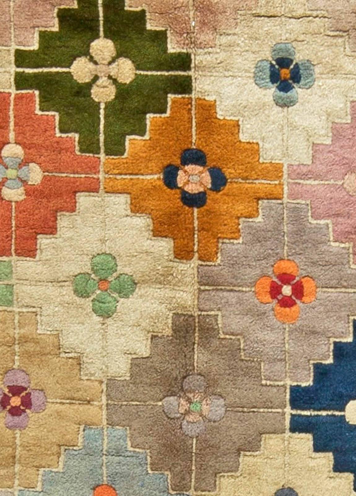 This circa 1940 vintage Chinese Deco rug features an all-over multicolored lozenge field containing floral abstractions, and a border of a lattice that repeats the color scheme of the primary pattern. Featuring shades such as blue, lilac, beige, red