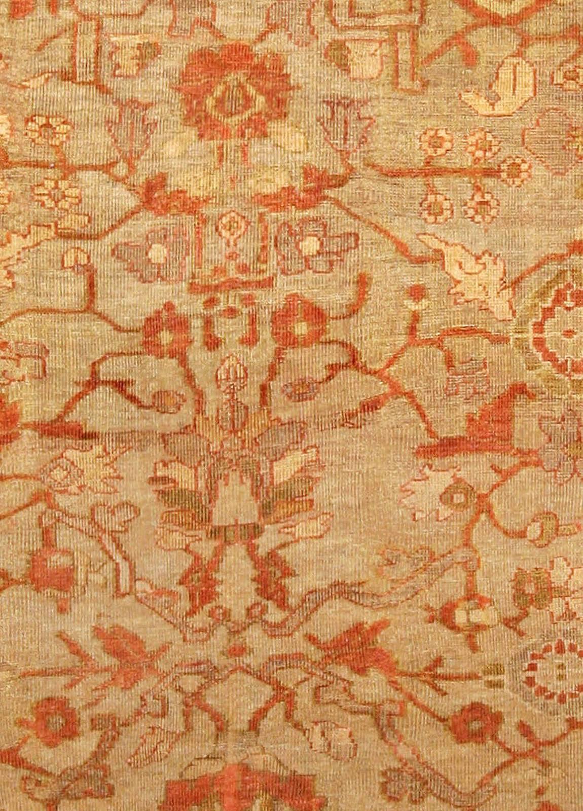 A late 19th century Persian Sultanabad antique rug, the camel field with an allover rust, beige and cream lattice of flowering vine and palmettes, within a playful rust border of enlarged palmettes and blossoms.