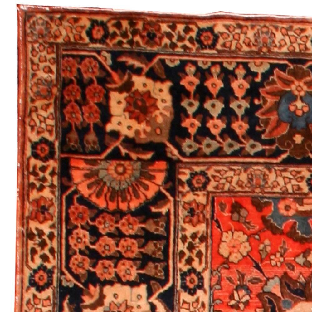 An early 20th century Persian Tabriz rug, the abrashed red field with an all-over trellis of palmettes and flowering vinery within a dark blue raceme and palmette border.