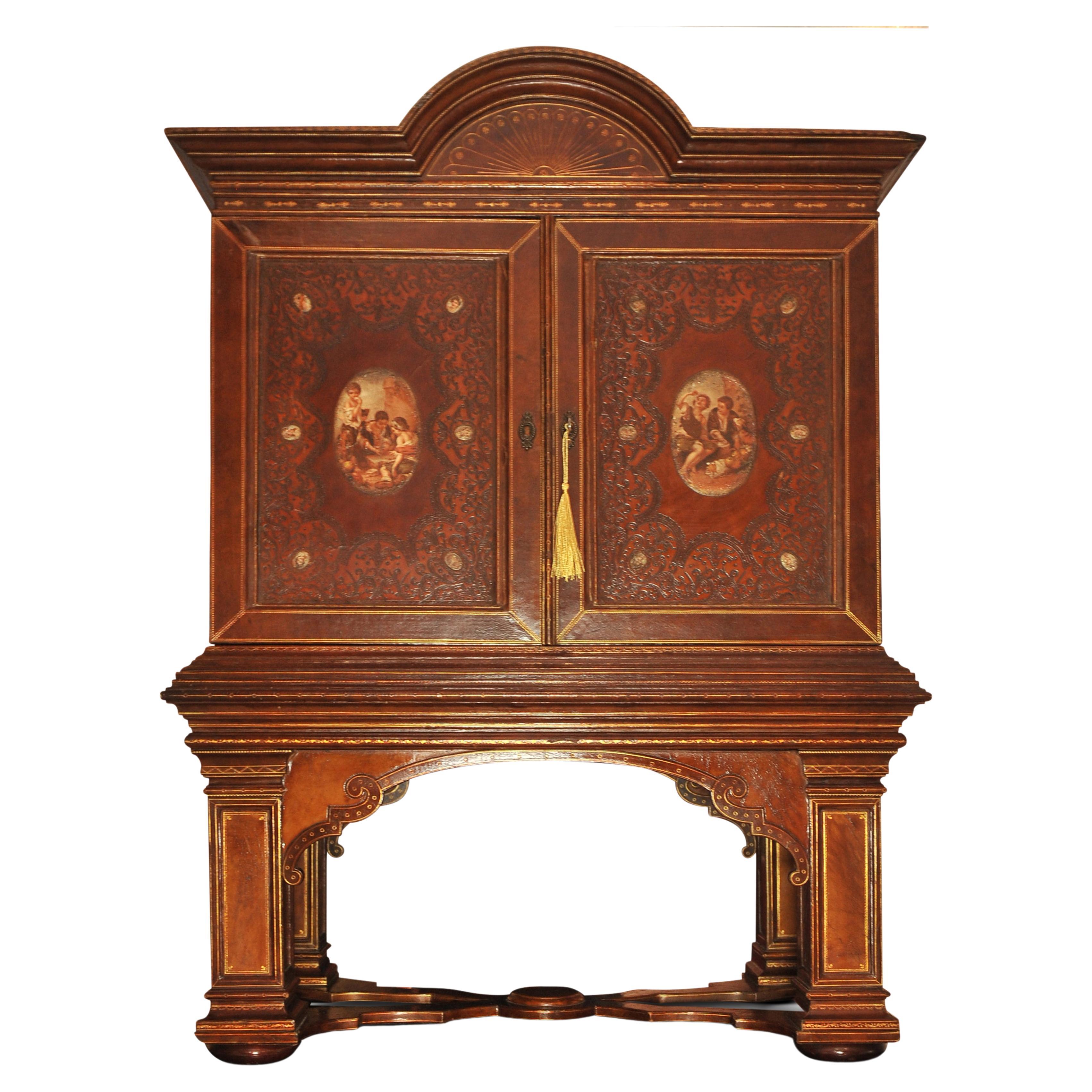 A 19th Century Handcrafted Tooled Brown Leather Italian Renaissance Design Fitted Writing Cabinet On Original Plinth

Featuring fourteen hand-painted portraits (after) Murillo, depicting day to day life.

The interior of the two door cabinet