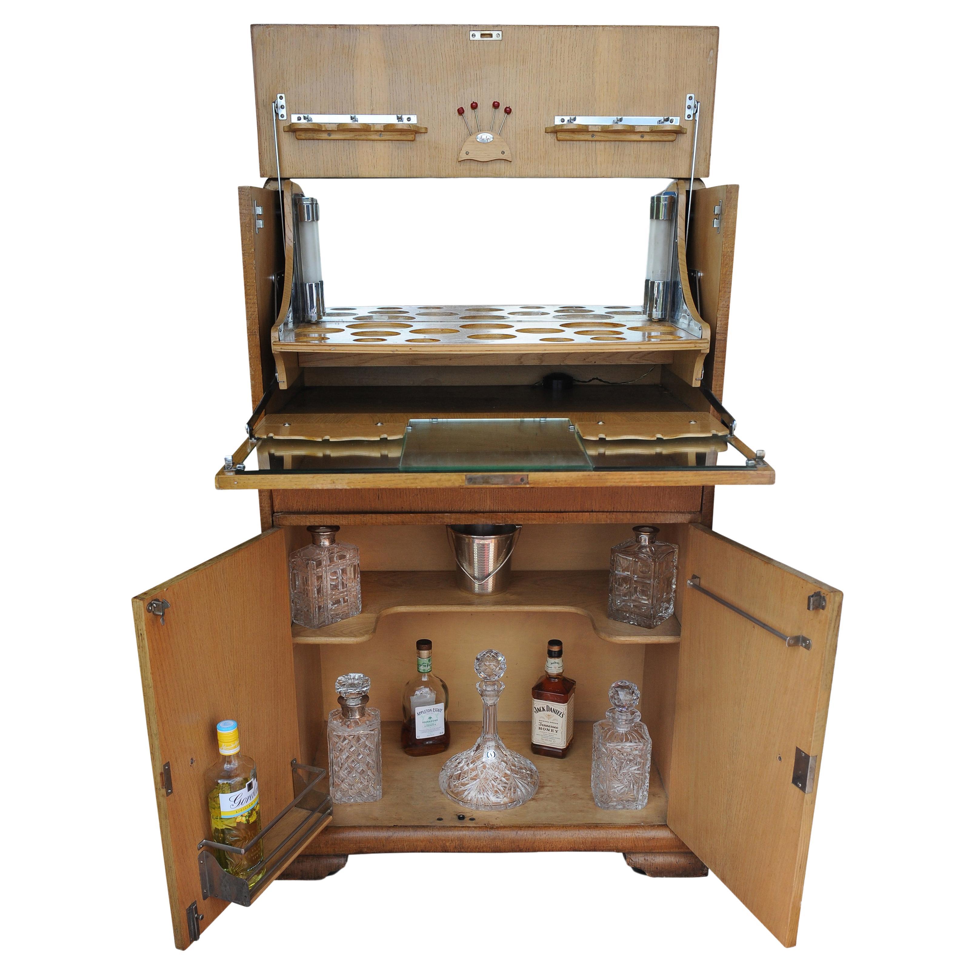 Eine luxuriöse Art-Déco-Cocktailbar. Das Spiegelkabinett ist mit einem Paar verchromter Säulenleuchten von Al-Wyn ausgestattet 

Die Eichenfurnier Dry Bar mit verspiegelten Innenleuchten, sind mit UK-Steckvorrichtungen ausgestattet.
 
Die Bar wird