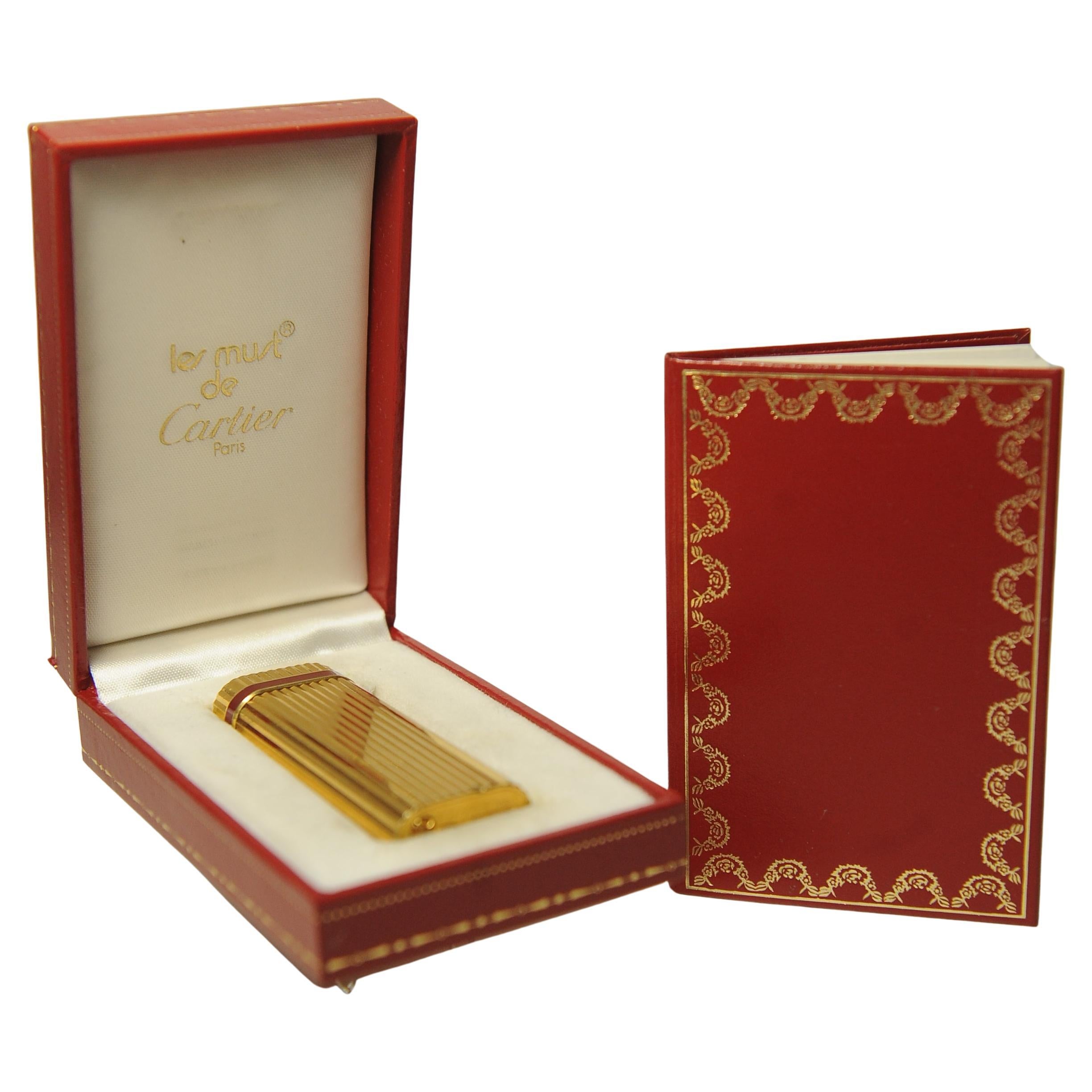 Elegant Gold Plated Must de Cartier Ribbed Godron Cigarette Lighter In Original Cartier Box.

Marked Cartier Paris To Lighter Base 

Complete With Original Box, Instructions 