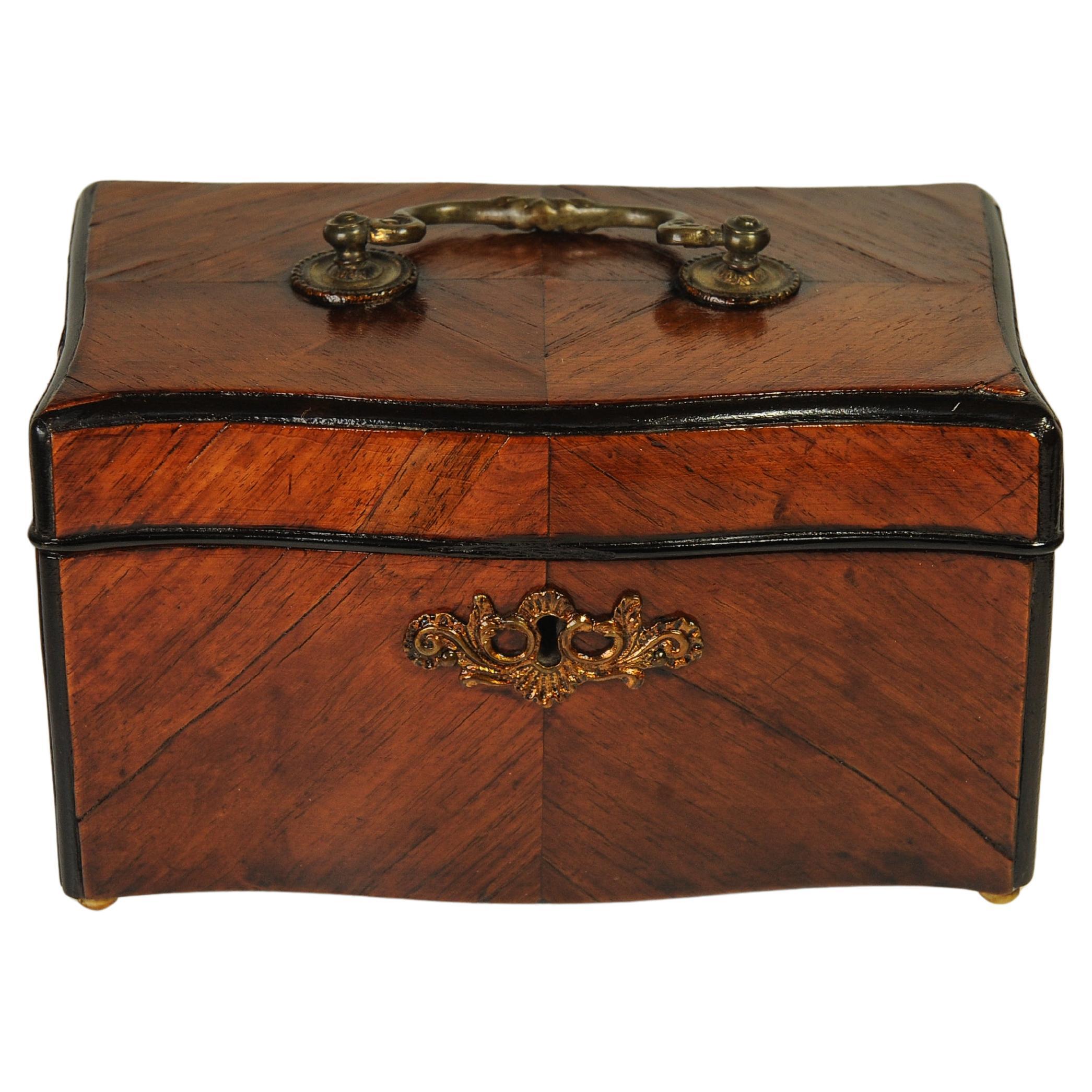 A 19th Century Antique English Victorian Ebonised Walnut Veneer Tea Caddy With Brass Handle & Lead Lining 

A Charming tea caddy with decorative walnut veneer parquetry. 

A tea caddy is a box, jar, canister, or other receptacle used to store tea.