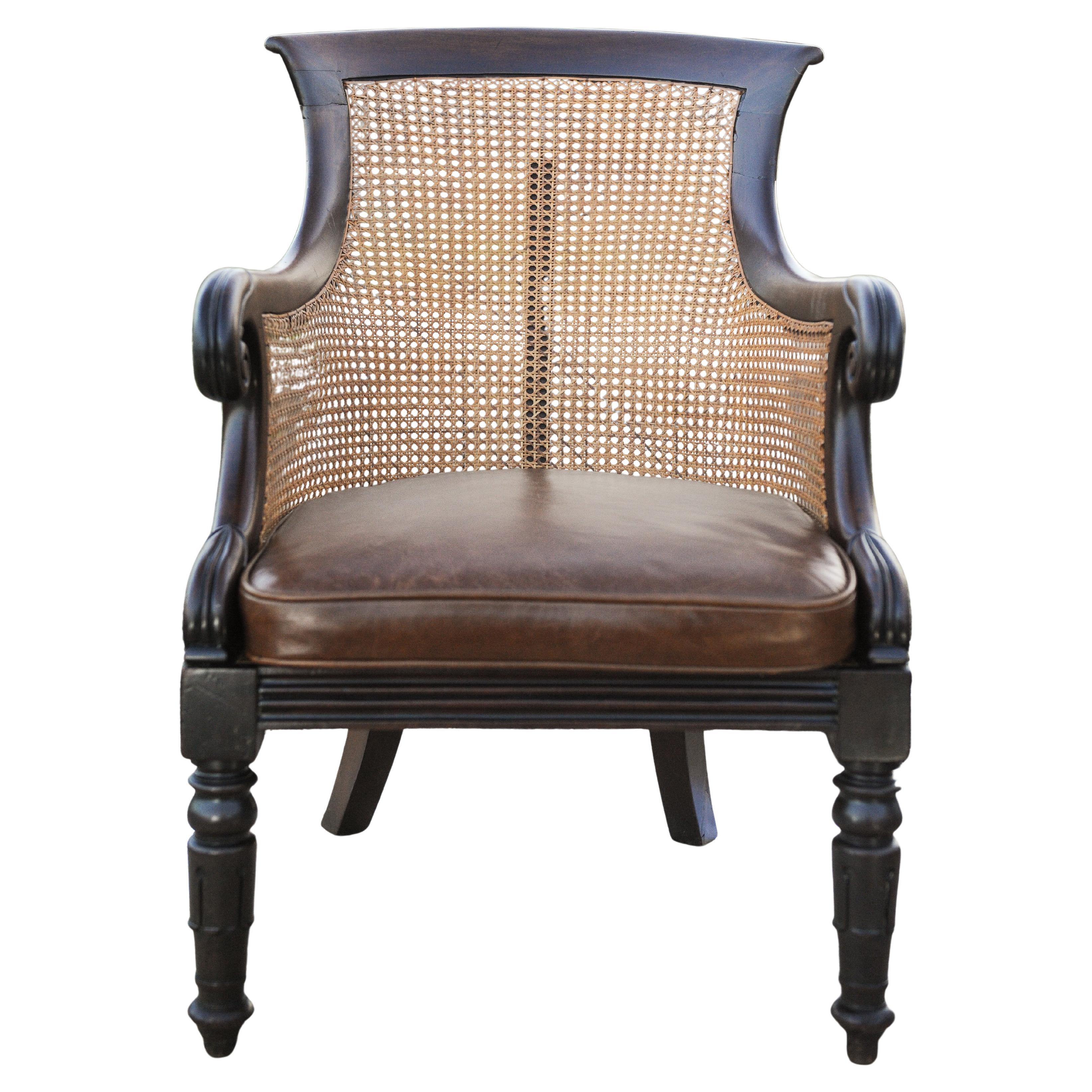 Stylish William IV 1700's Hardwood Cane Bergere Library Armchair With Scrolled Arms and Original Brass Castors on Fluted Supports.

Chair comes with a new brown leather piped cushion recently made to fit the chair.

Height 89.5cm I Width 57cm I