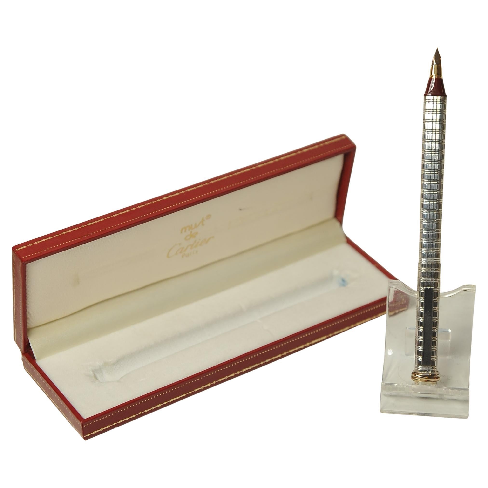 Penna stilografica Cartier Trinity vintage con pennino placcato oro 18ct e scatola 

Questa penna stilografica Must de Cartier ha un corpo in metallo tornito in argento con motivo gadroon. 

Rifinito con l'iconico anello Trinity nella parte