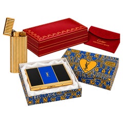 Encendedor «Godron» de Cartier chapado en oro de 18 quilates, pitillera de Yves Saint Laurent y cajitas