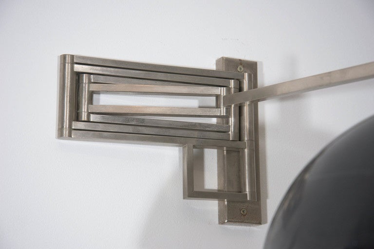 Made from polished nickel this 1980s wall light still has its original metal shade. Arm adjusts from 20