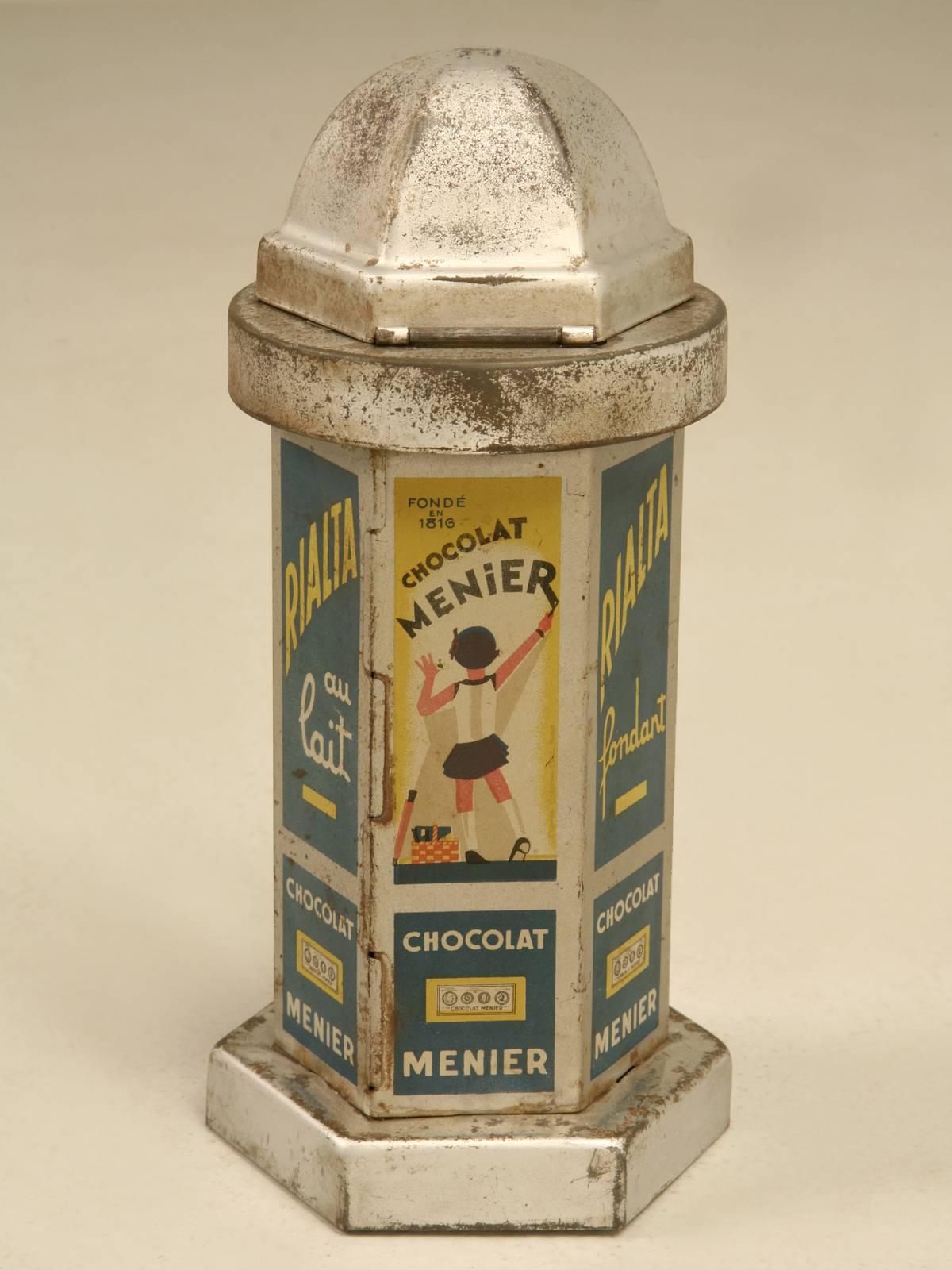 Small silver-lacquered sheet metal Chocolate dispenser designed as city Kiosk with printed decoration of the brand’s advertisements. 
In 1830 the Menier company made its first mechanized mass production factory for cocoa powder in France. Following
