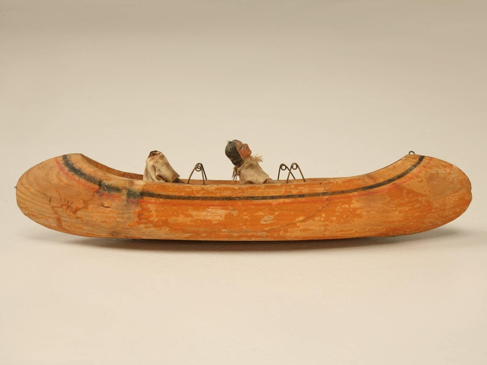 American folk-art canoe, probably from Alaska, but could also be American Indian. Has quite a bit of age to it and I would expect it was made in the early 1800s. The canoers are made from seal skin and one is missing its head, but we could fabricate