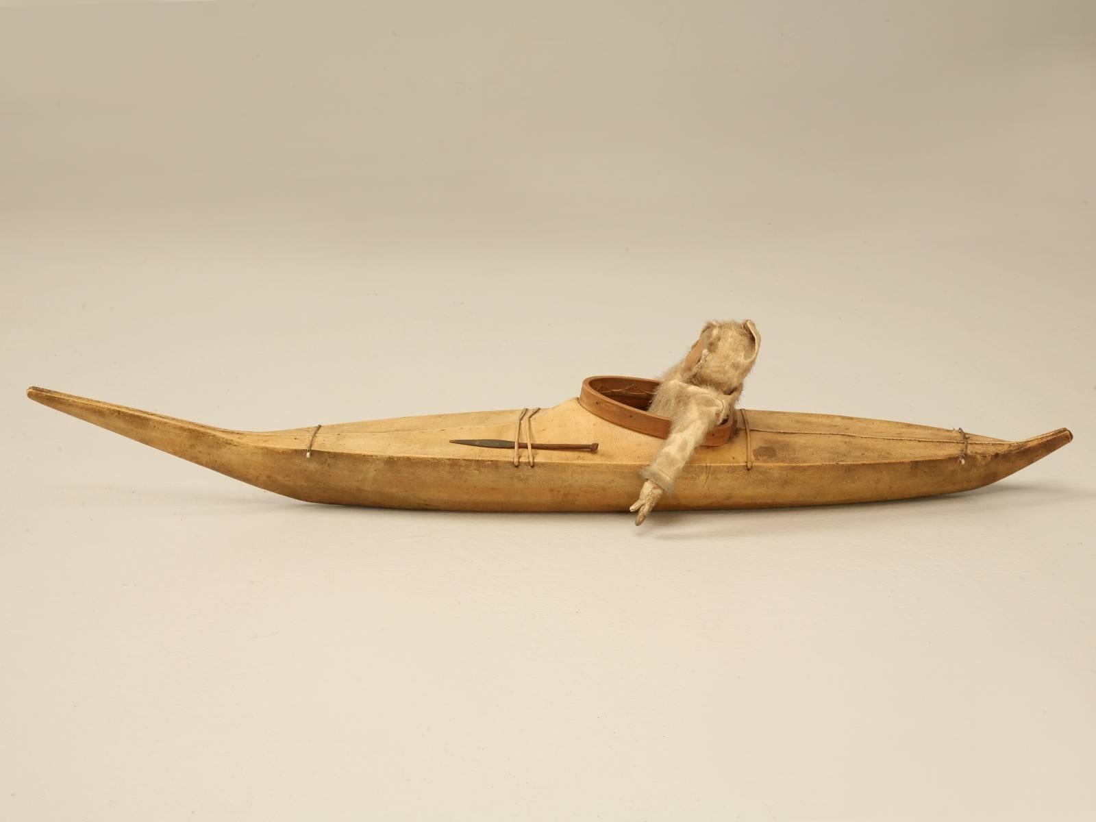 Handmade around the turn-of-the-century, this kayak is constructed of seal skin tightly wrapped over a wooden skeleton frame. The fisherman is original and is covered in fur. This is just one of several we will be offering on 1stdibs from a private
