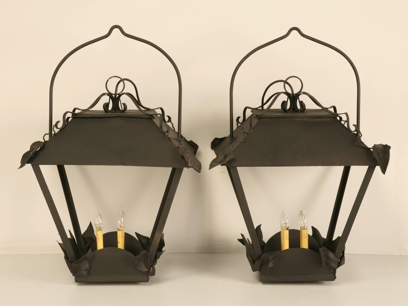 Matched pair of large-scale French lanterns probably dating from the 1950s. They are unusually large and we have never seen this style before with the leaves decorating the top section. Our shop rewired the lanterns and installed USA sockets and