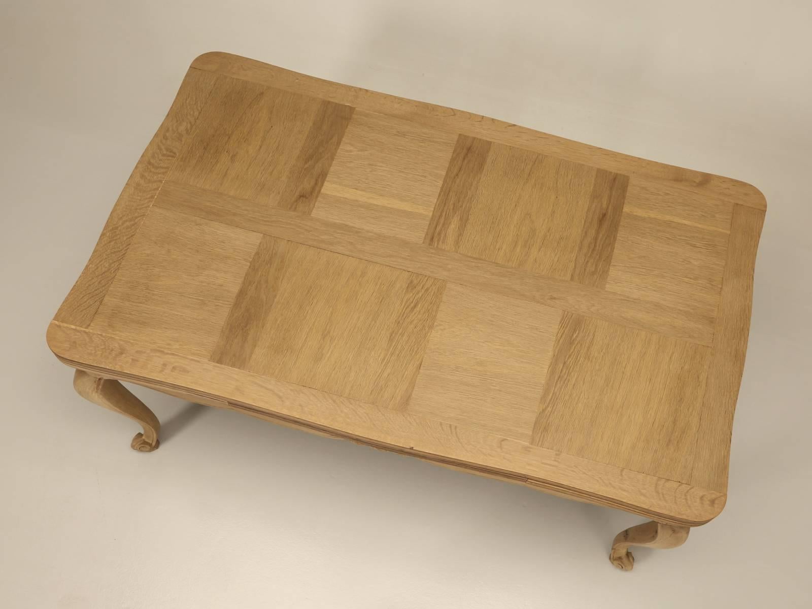 Table de salle à manger française à rallonges qui a été soigneusement dépouillée de sa finition d'origine et transformée pour ressembler à du chêne blanc brut, mais avec une couche protectrice transparente invisible et mate. La structure a été