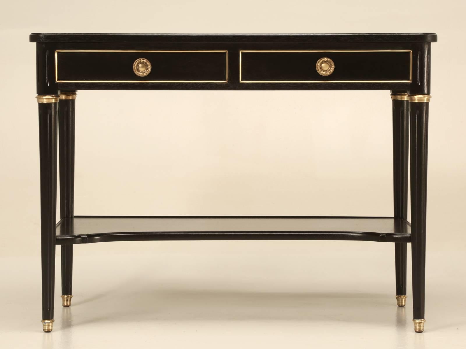 Vintage French petite console table that can be used for a myriad of different applications. Our old plank finishing department hand stripped the old tired mahogany and slowly ebonized the wood to a near perfect finish. Difficult to find a piece
