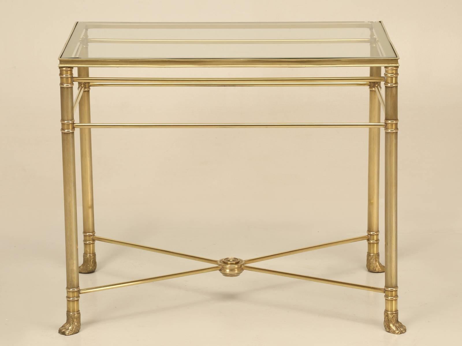 Elegant vintage French solid brass Mid-Century Modern end table with a glass top. Polished un-lacquered brass that will oxidize over time, unless you would like us to re-lacquer the brass for you?  **Please note that the glass top has two damaged