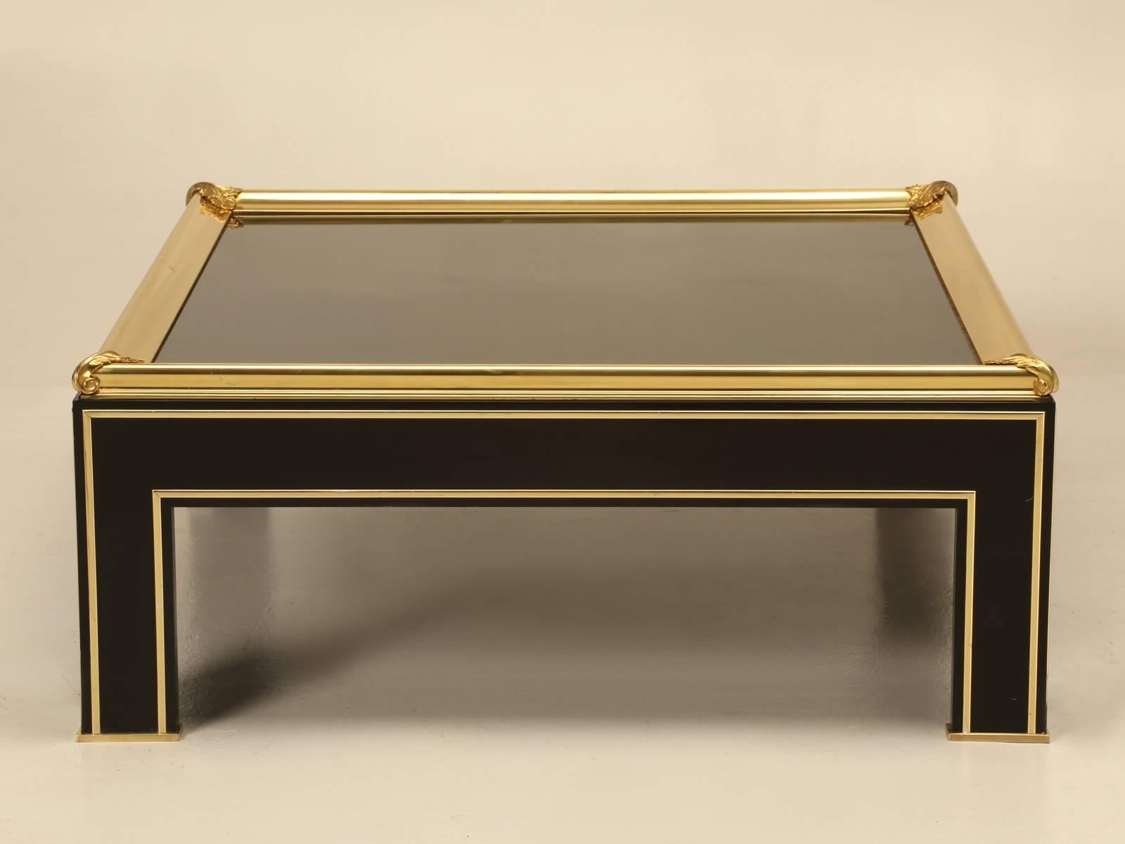 In the style of Maison Jansen this extremely elegant square French Coffee Table is finished in Black Lacquer, Polished Brass and capped off with a Black Mirror Coffee Table Top. We cannot see any prior repairs, but please keep in mind that like all