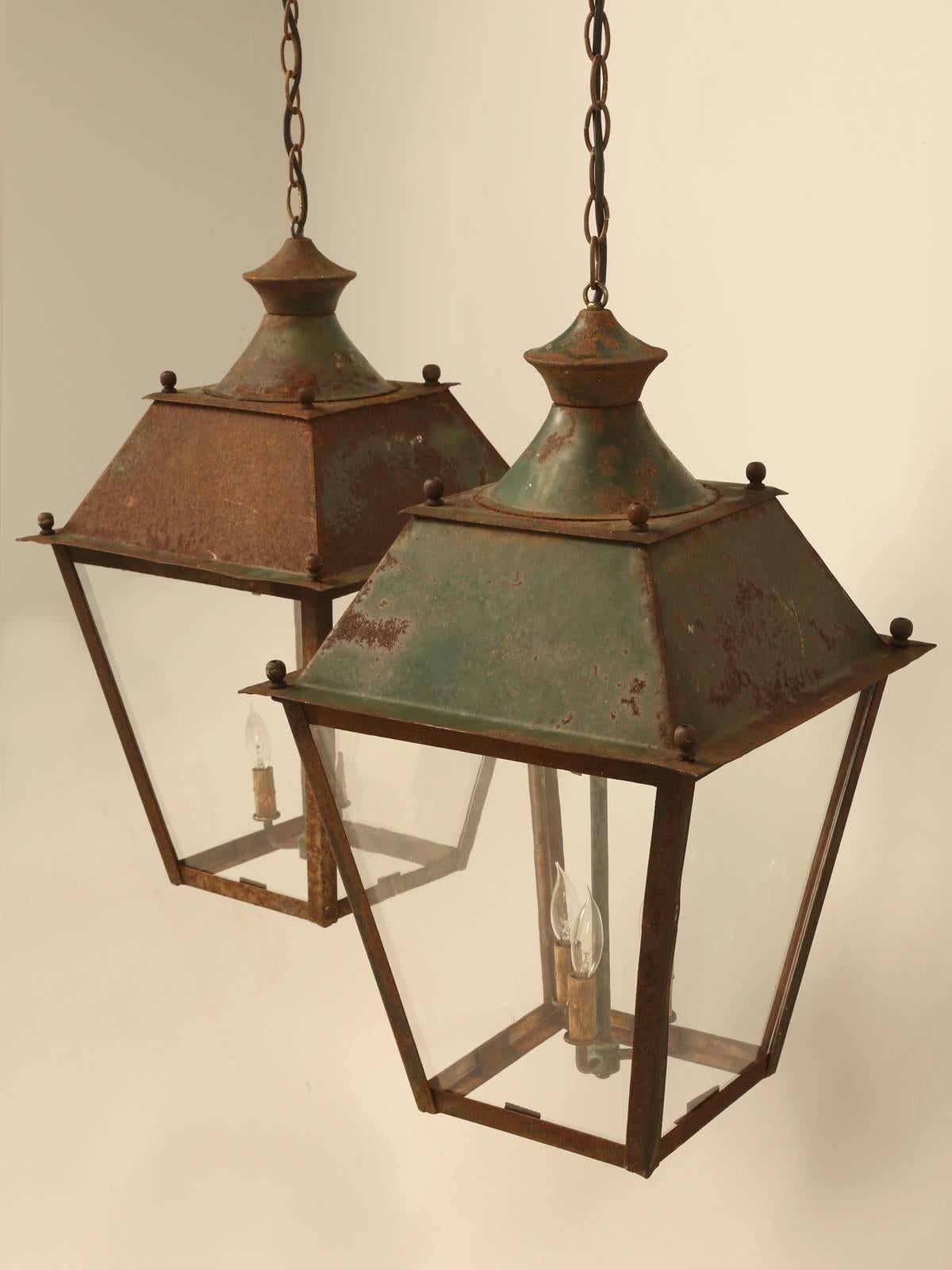 Matched pair of French hanging indoor, or outdoor lanterns in their original paint. We struggled a bit whether or not to refinish the exteriors, but we just loved the hints of old green paint showing and could not bring ourselves to cover it up.
