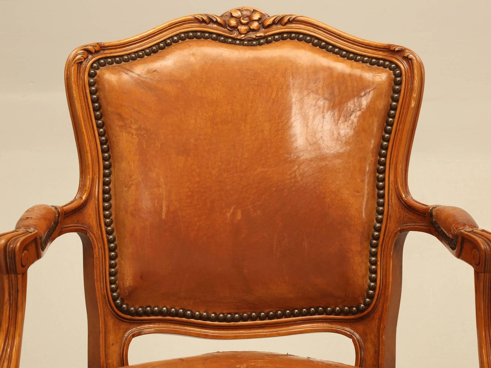 Conjunto de (4) sillones franceses vintage de estilo Luis XV aún en su tapicería de cuero original. El cuero es de un intenso color silla de montar y sigue siendo útil tal como está. Los bastidores tienen un buen peso y están bien hechos,