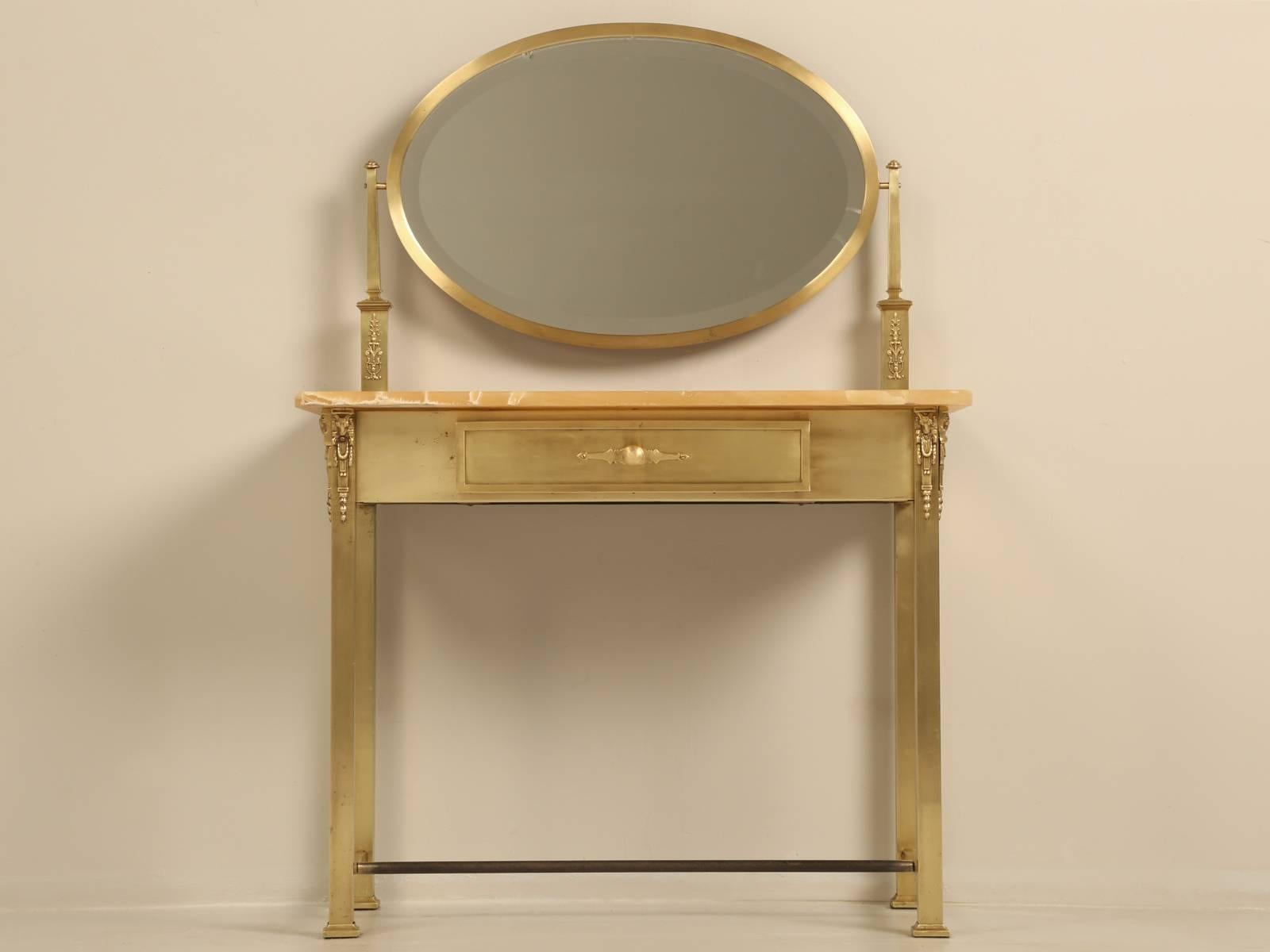 French dressing table or potential bathroom vanity, constructed of onyx and solid brass with matching mirror. Because onyx is a soft stone there, will be minor surface scratches and we included a blowup picture of one chip. Ideal for a vessel