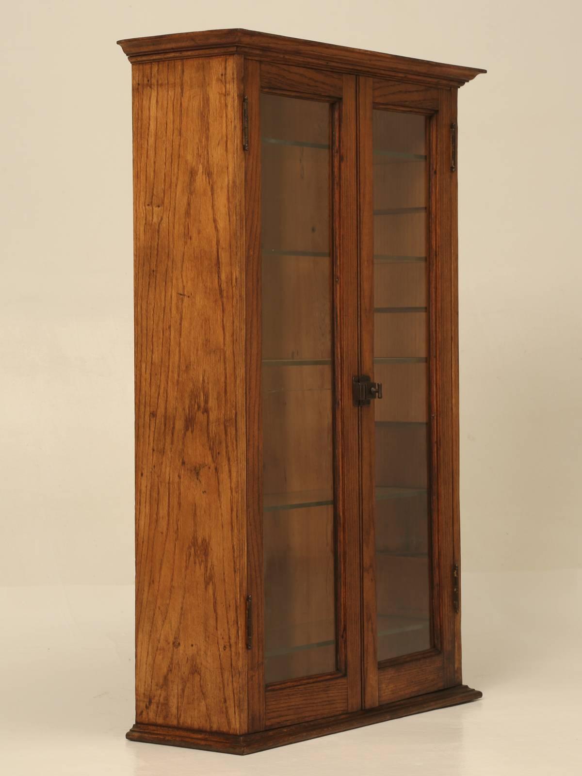 Very nice old American oak hanging, or free standing glass bookcase, or curio cabinet. All original and never buggered about with, but please note the perfectly horizontal crack in the door glass. Probably made in the early 1900s.