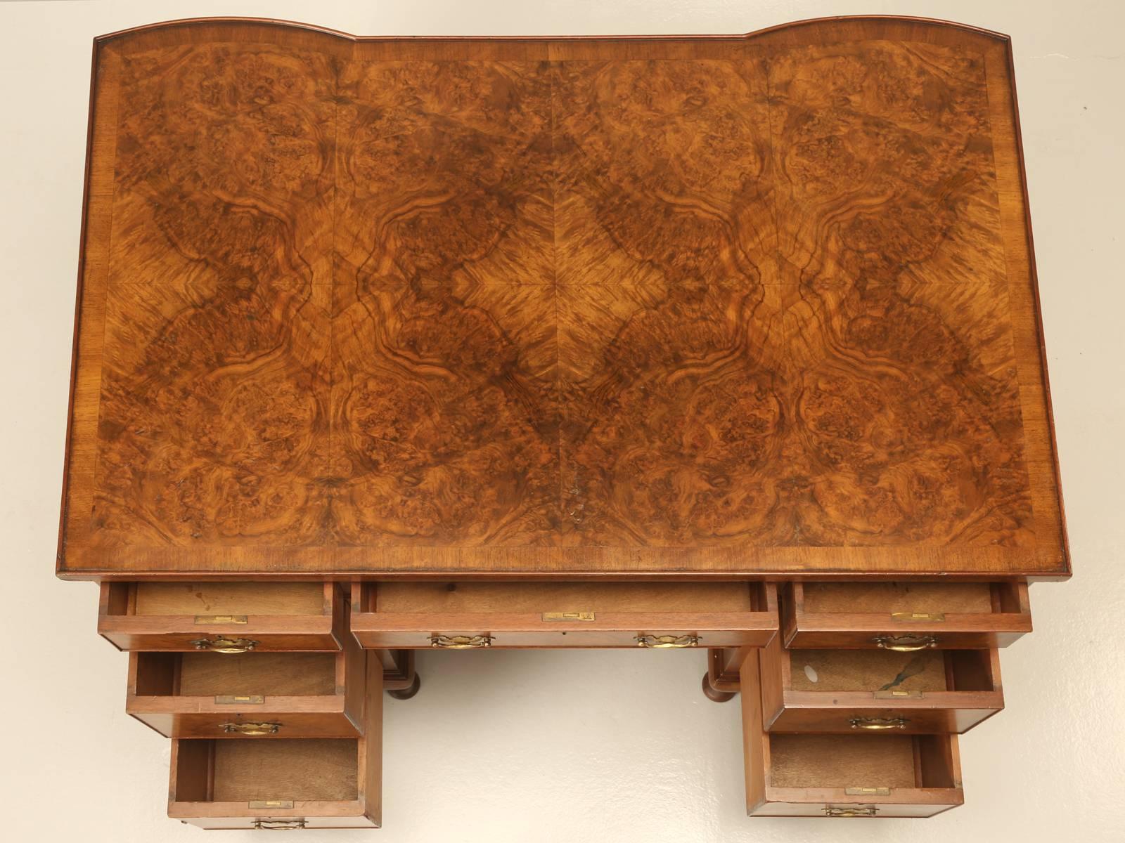 A stunning antique English Edwardian walnut partner's desk, circa 1910.
This charming desk with burl walnut veneered top and drawer facings comes with three frieze drawers and four deep drawers for holding files. The cabinet doors to the opposite