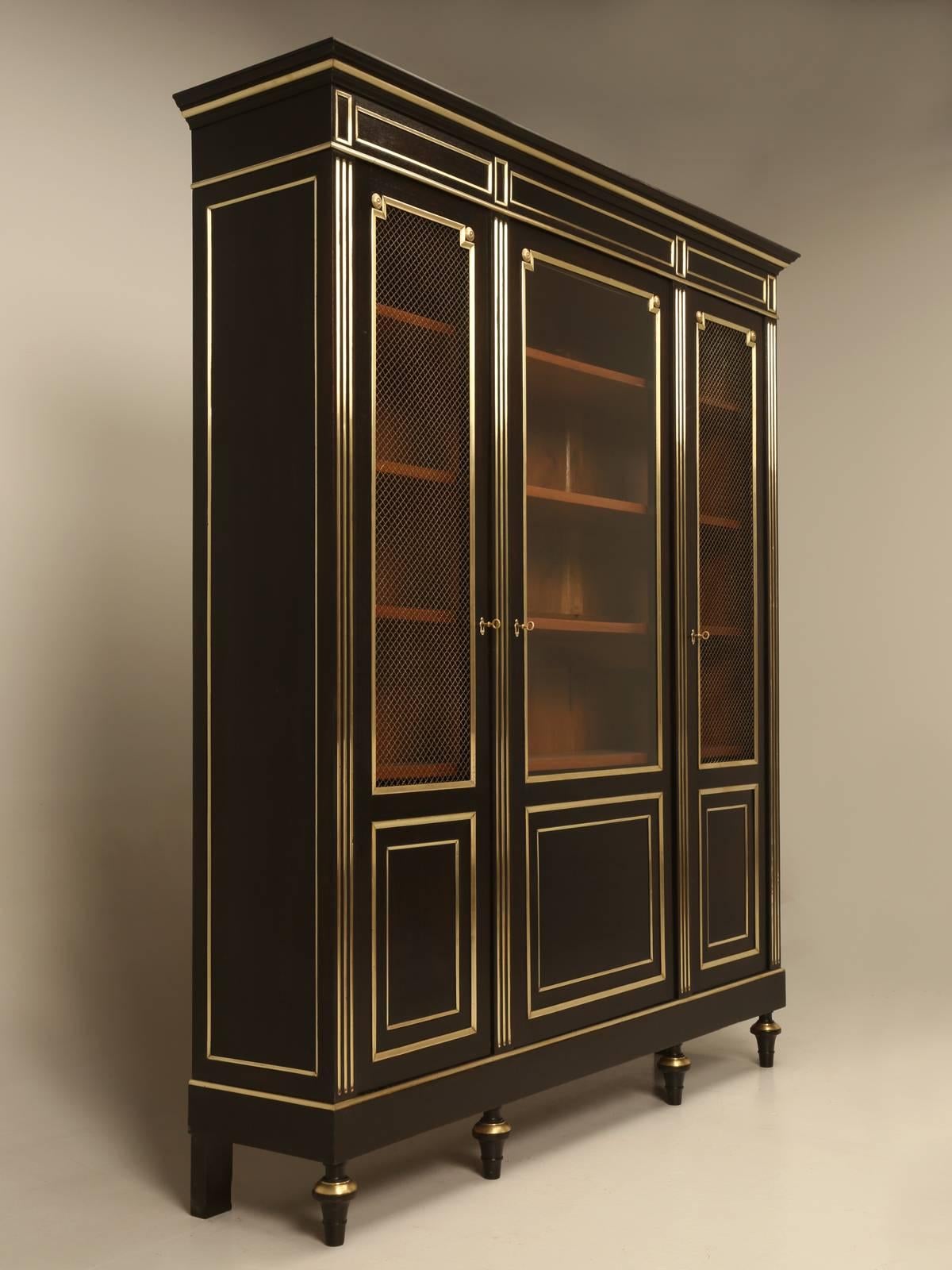 Antique French Louis XVI style ebonized bookcase, or as the French would all it, a bibliotheque. Our old plank workshop completely disassembled the bookcase and hand scraped and hand sanded the solid mahogany cabinet, before sending it into our