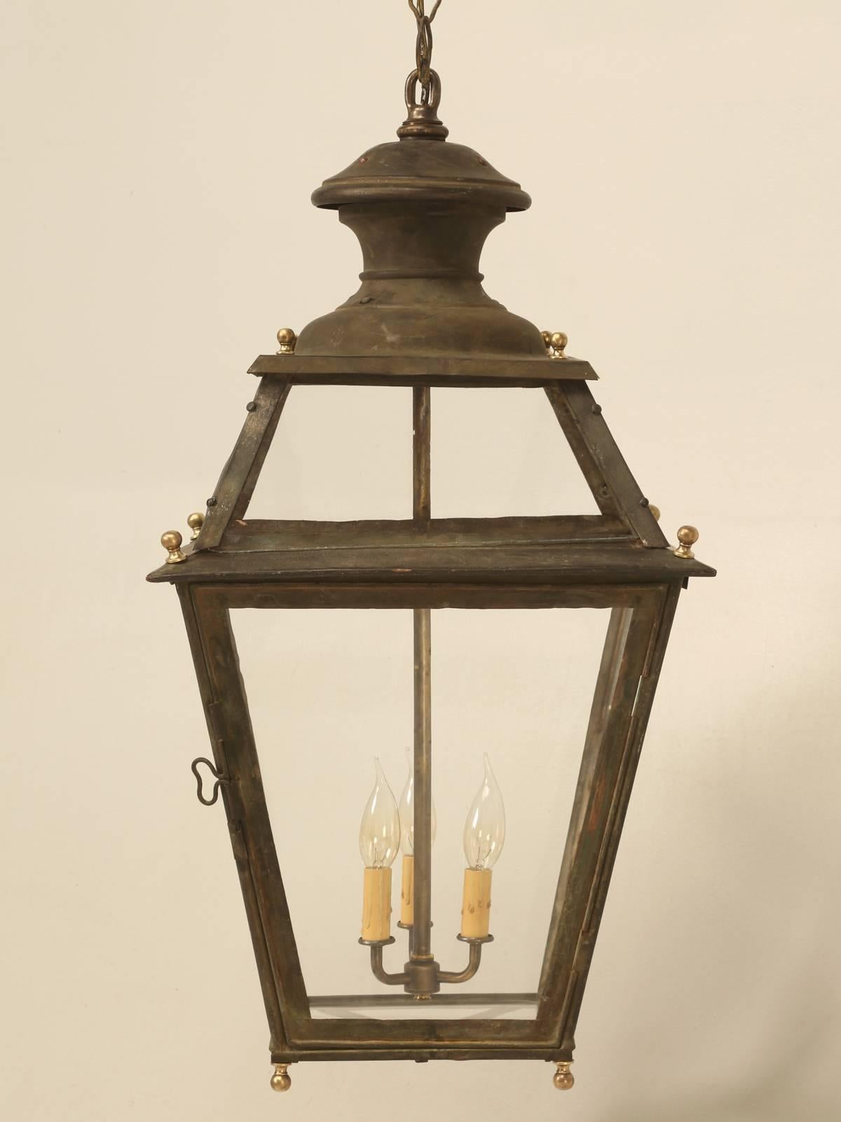 Antique French hanging copper lantern with a spectacular patina that no one could fake this good. We rewired the lantern and installed the original handmade wavy French glass for the perfect look. Will accept (three) 60 watt bulbs. 

Comes with a