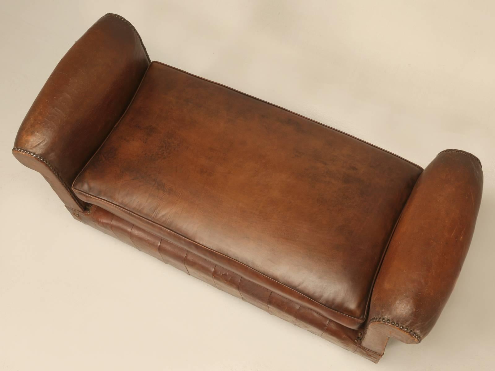 Antique French leather daybed, with a restored seat cushion, but everything else on the bed is original. Probably made in the late 1930s and was purchased in a small-town east of Bordeaux in southwest region of France. Because of it diminutive size,