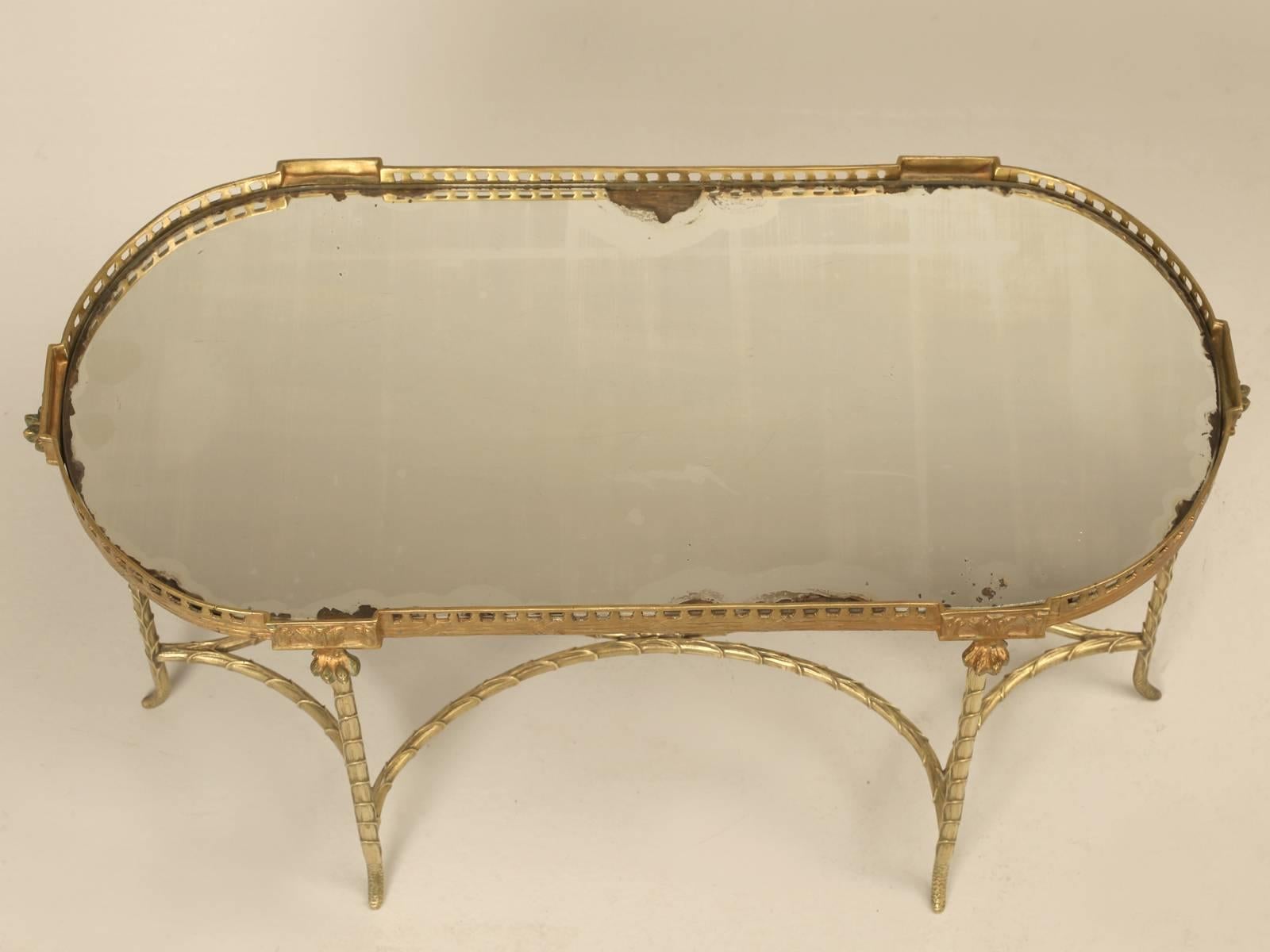 French small oval coffee table, attributed to the House of Bagues and made of solid bronze in a faux bamboo motif. We could not decide about the original heavily distressed mirror coffee table tray top, so we went ahead and made a new one, for those