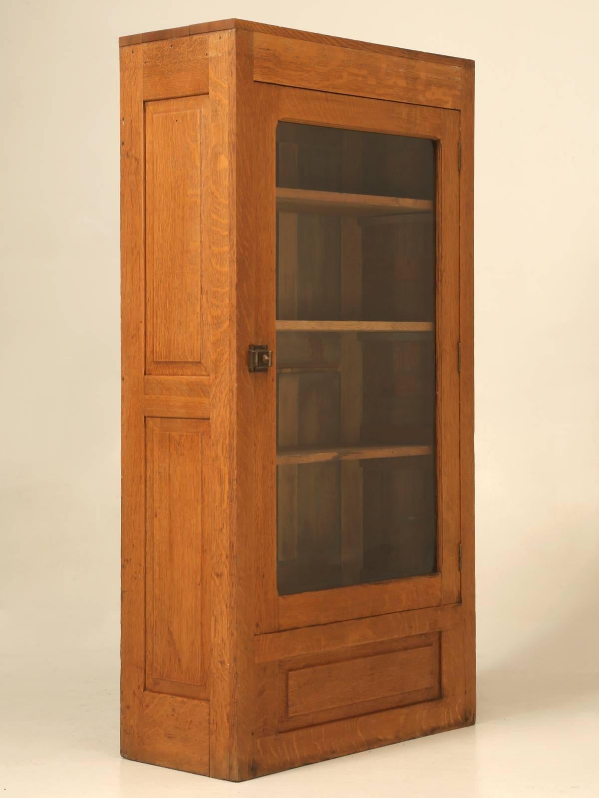 Antique American Oak bookcase, or Cabinet that appears to have been made in the early 1900s and does not appear to have been restored. We took steel wool to the old finish and applied a couple of coats of beeswax and left the original patina as is.