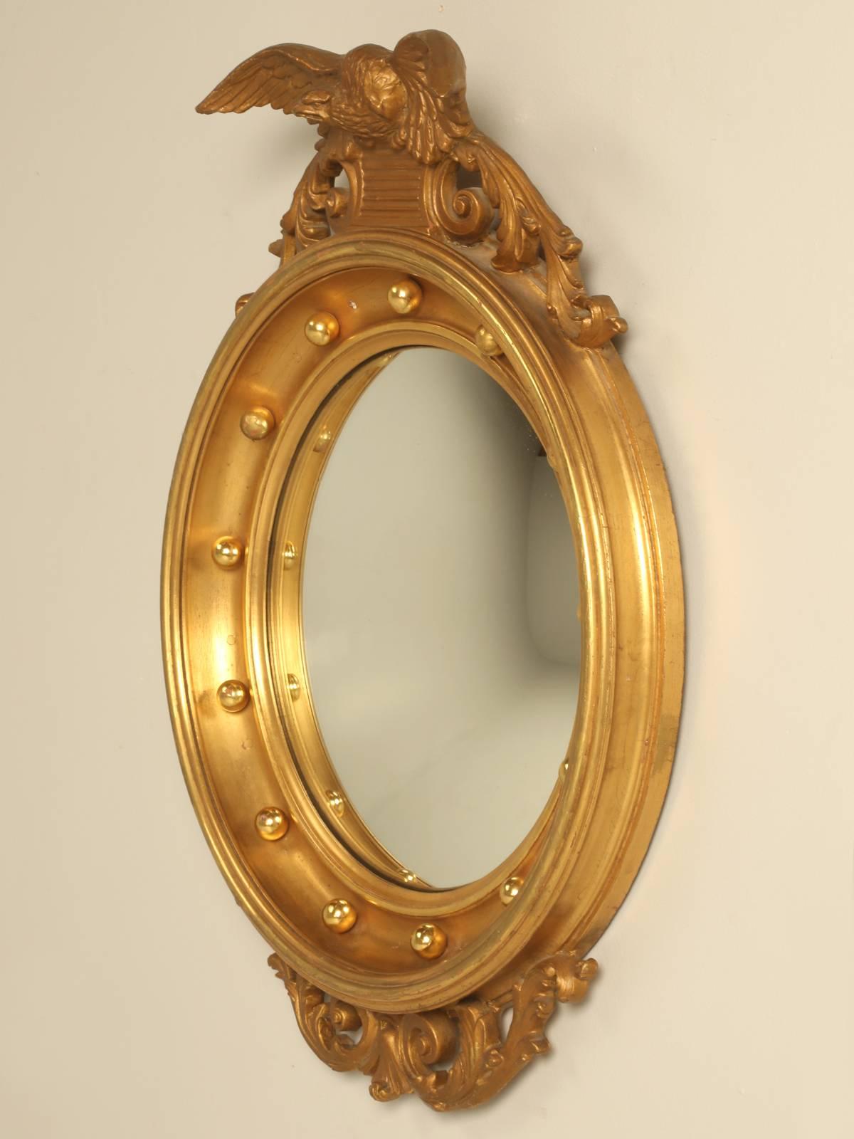 Regency eagle convex mirror with a gold leaf finish, probably from the 1950s or 1960s. This one is carved wood and not foam like so many of the current reproduction versions. No prior repairs.