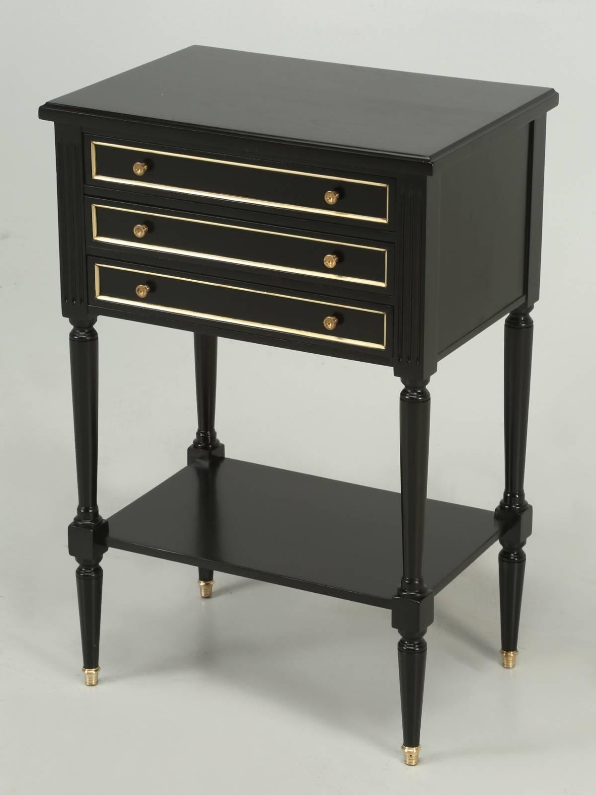 Beautifully restored in an old world ebonized black Louis XVI style nightstand, or side table with brass trim. The grain of the mahogany still shows through the finish and the drawers function as new. This was probably made post the big war and our