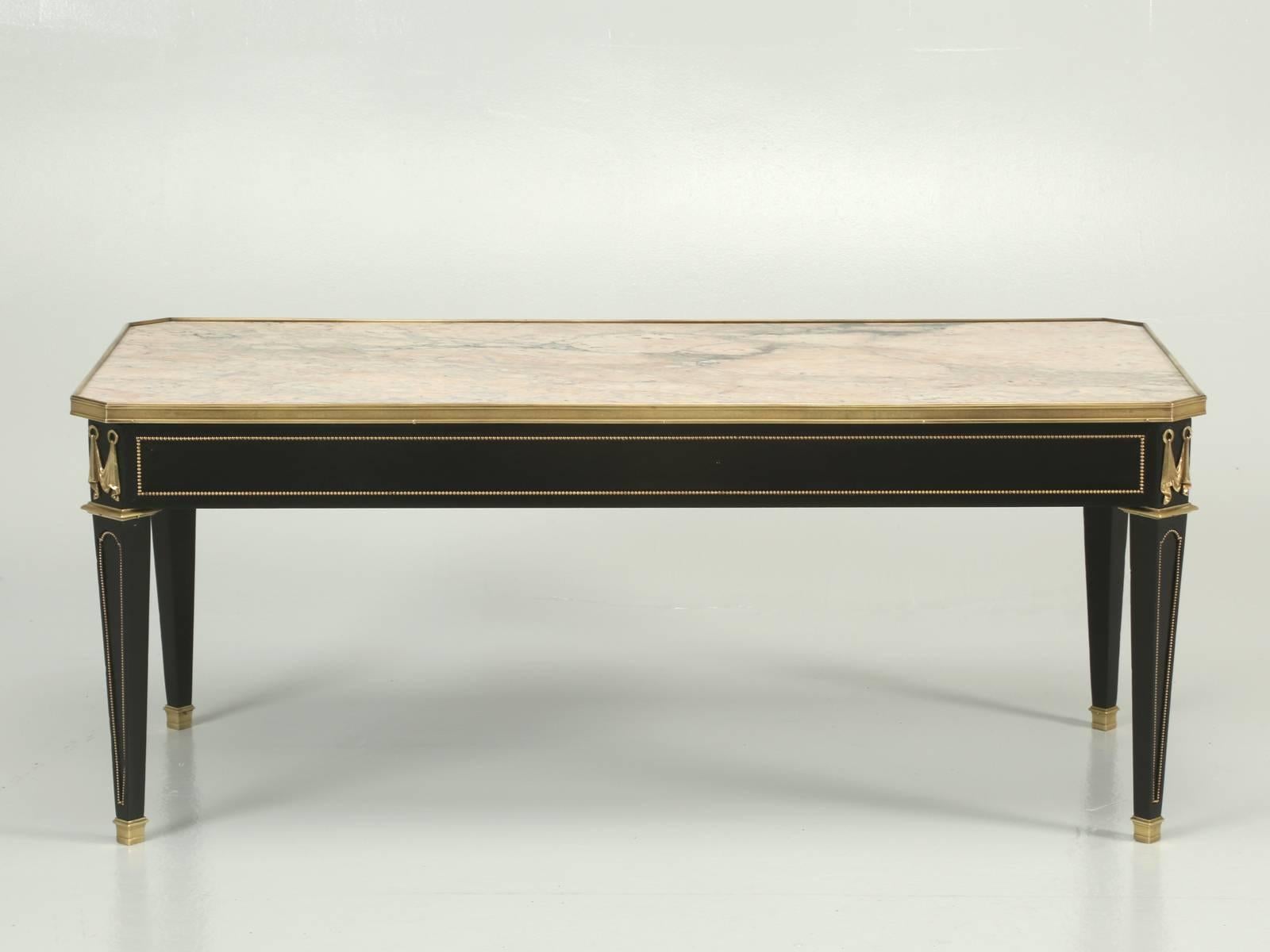 French ebonized mahogany coffee or cocktail table with solid brass accents, that has been totally dismantled and restored by our Old Plank workshop. There are no current, or prior cracks to the marble. This is a very elegant coffee or cocktail table