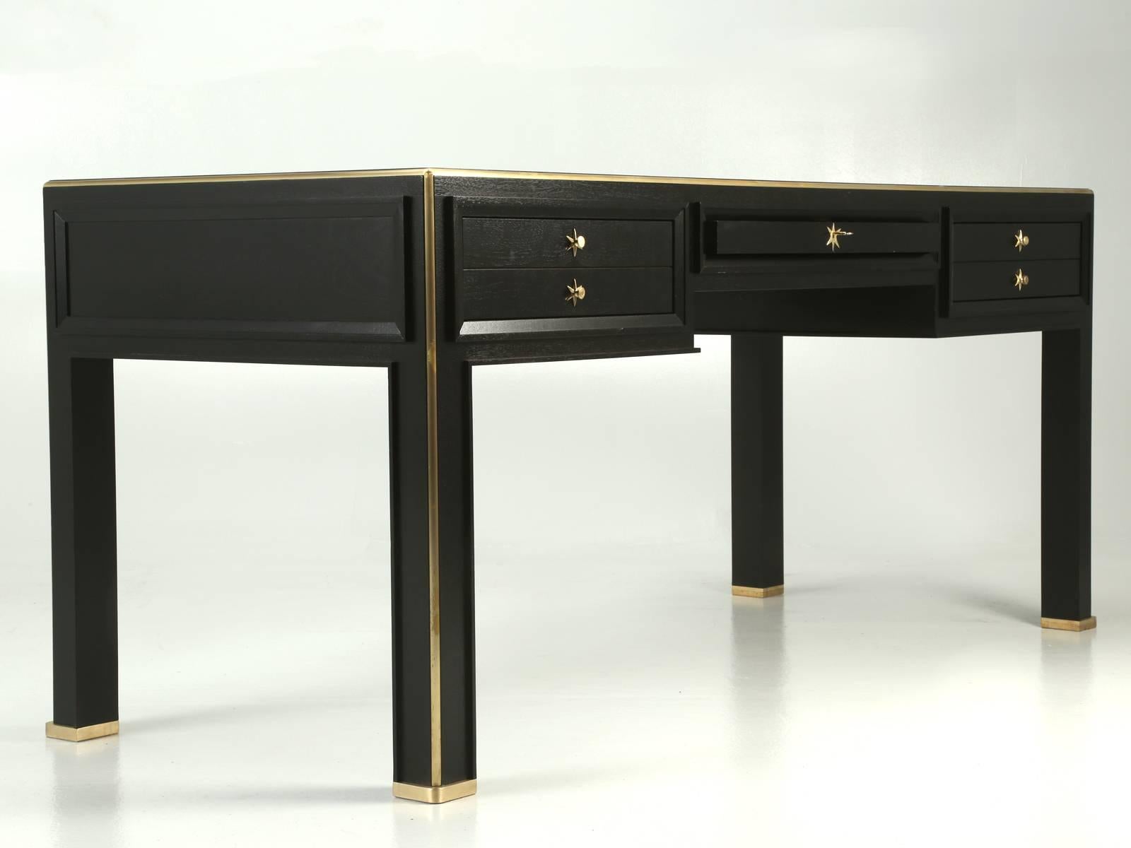 Recently constructed from our in house Old Plank workshop, this particular Jacques Adnet inspired desk, was made from solid mahogany that we ebonized. The large quarter round trim is solid brass that we machined to fit precisely and the leather top