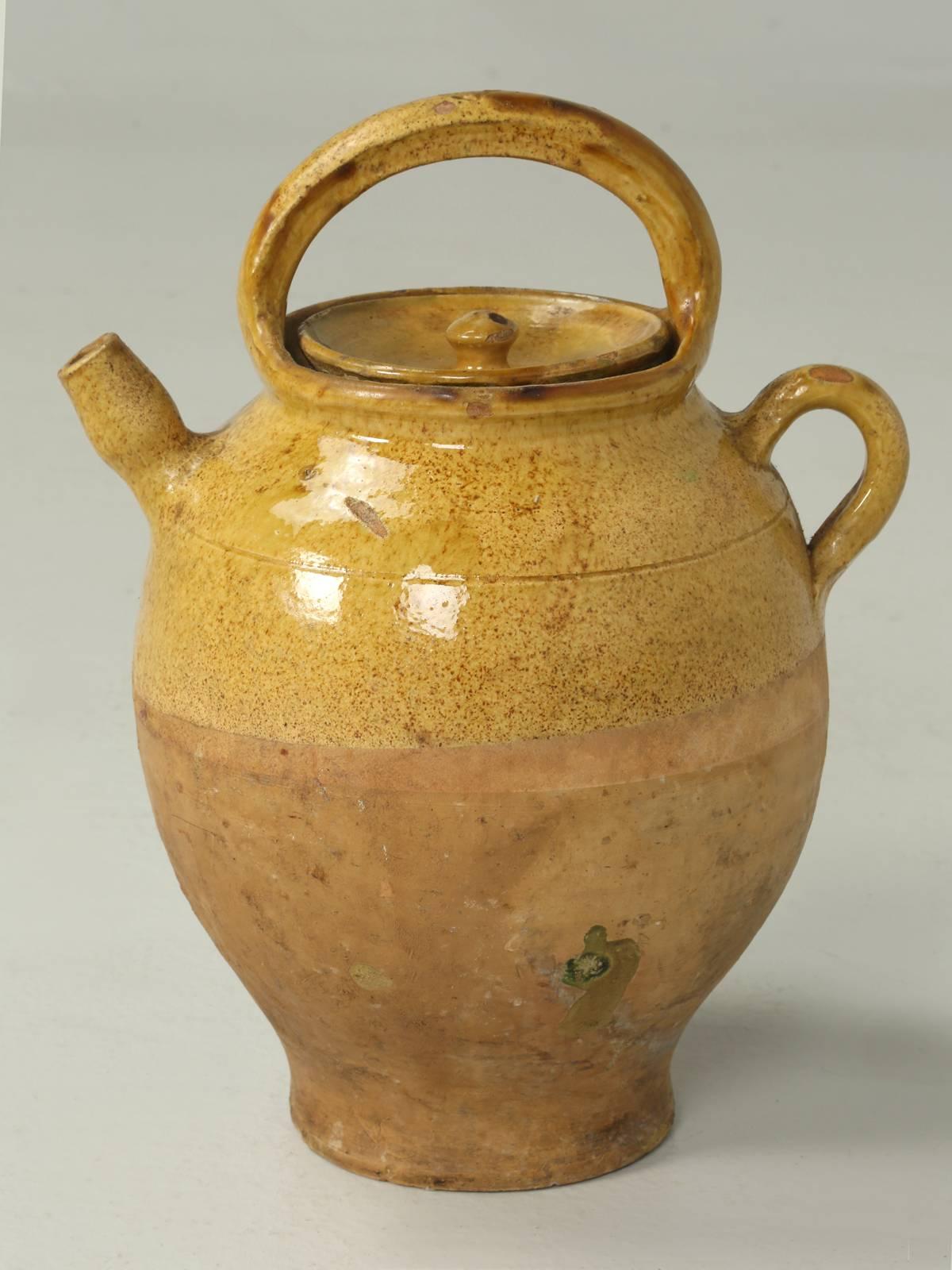 Antique French authentic ceramic water pitcher, or 'cruche', with an unbroken handle and complete with its original lid. The antique French jug or pitcher was made of ochre-glazed terracotta earthenware and was used to transport water and were