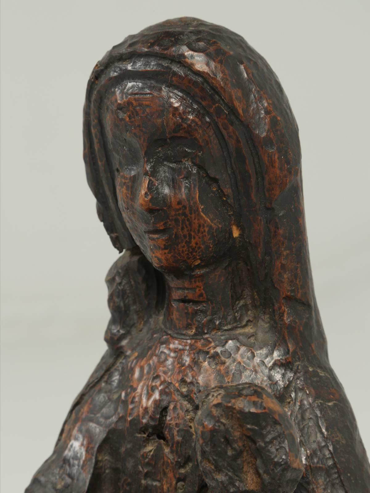Rustic wood carving of a woman holding a child. The carving is from Spain and we were told it dates from the late 1600s and it looks that hold in real life. The woman appears to be missing part of her arm and if you were so inclined, we could
