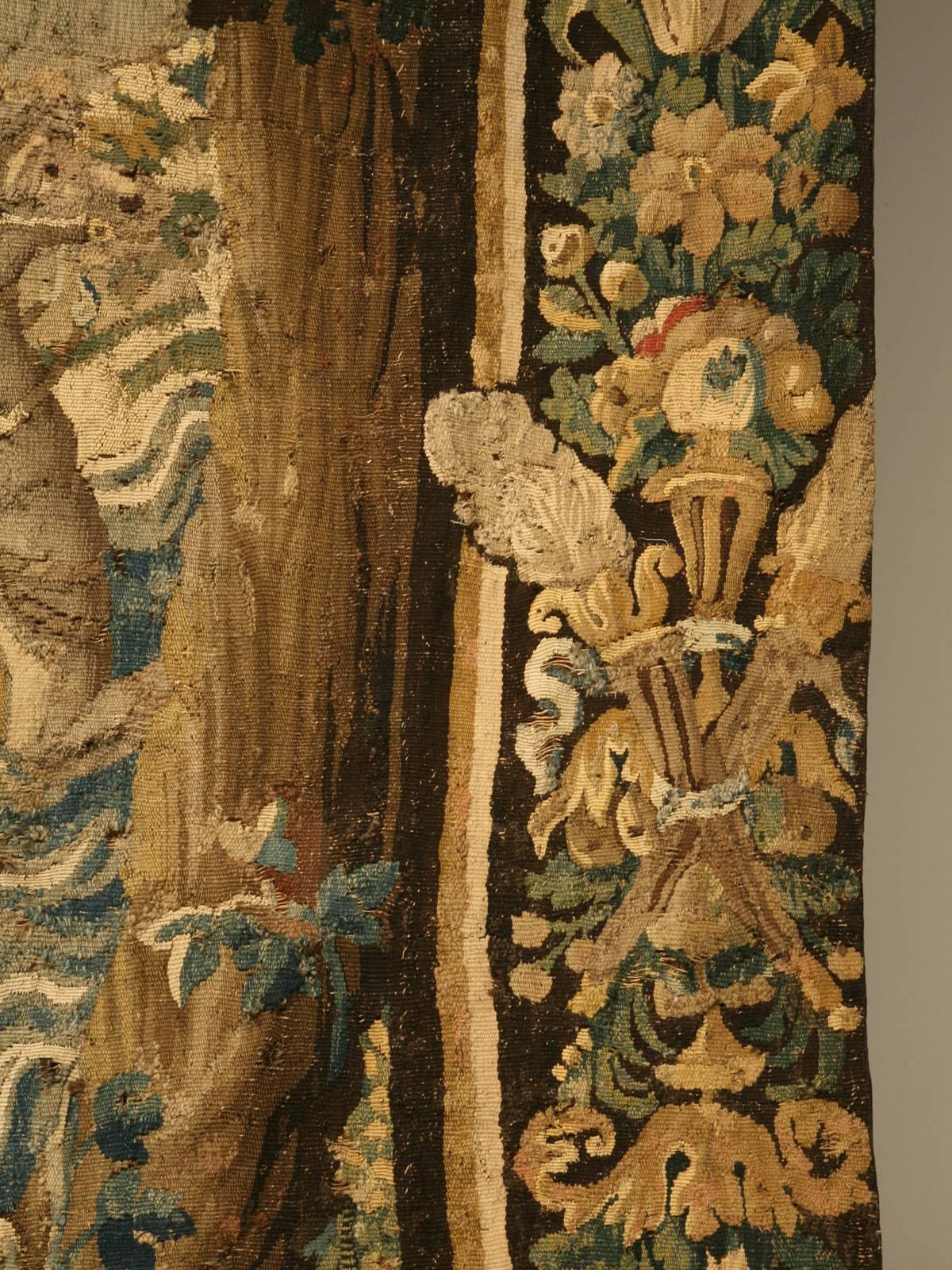 This tapestry was woven in Aubusson, France circa 1650s and is documented. It has its original floral border and beautiful verdure and classical motifs. There are many condition issues and it has had more than its share of repairs. We actually drove