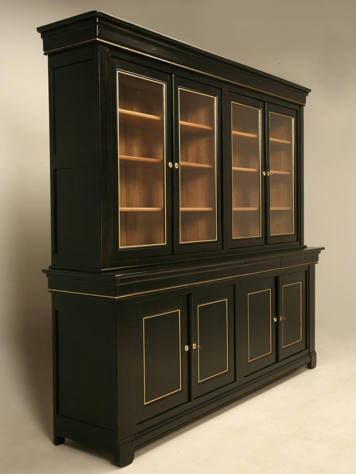 French Louis Philippe style grand bookcase in an ebonized finish with gold detailing. Our workshop went through the cabinet from top to bottom and spent over 80 hours making sure everything is functioning as it should. The interior was left in a