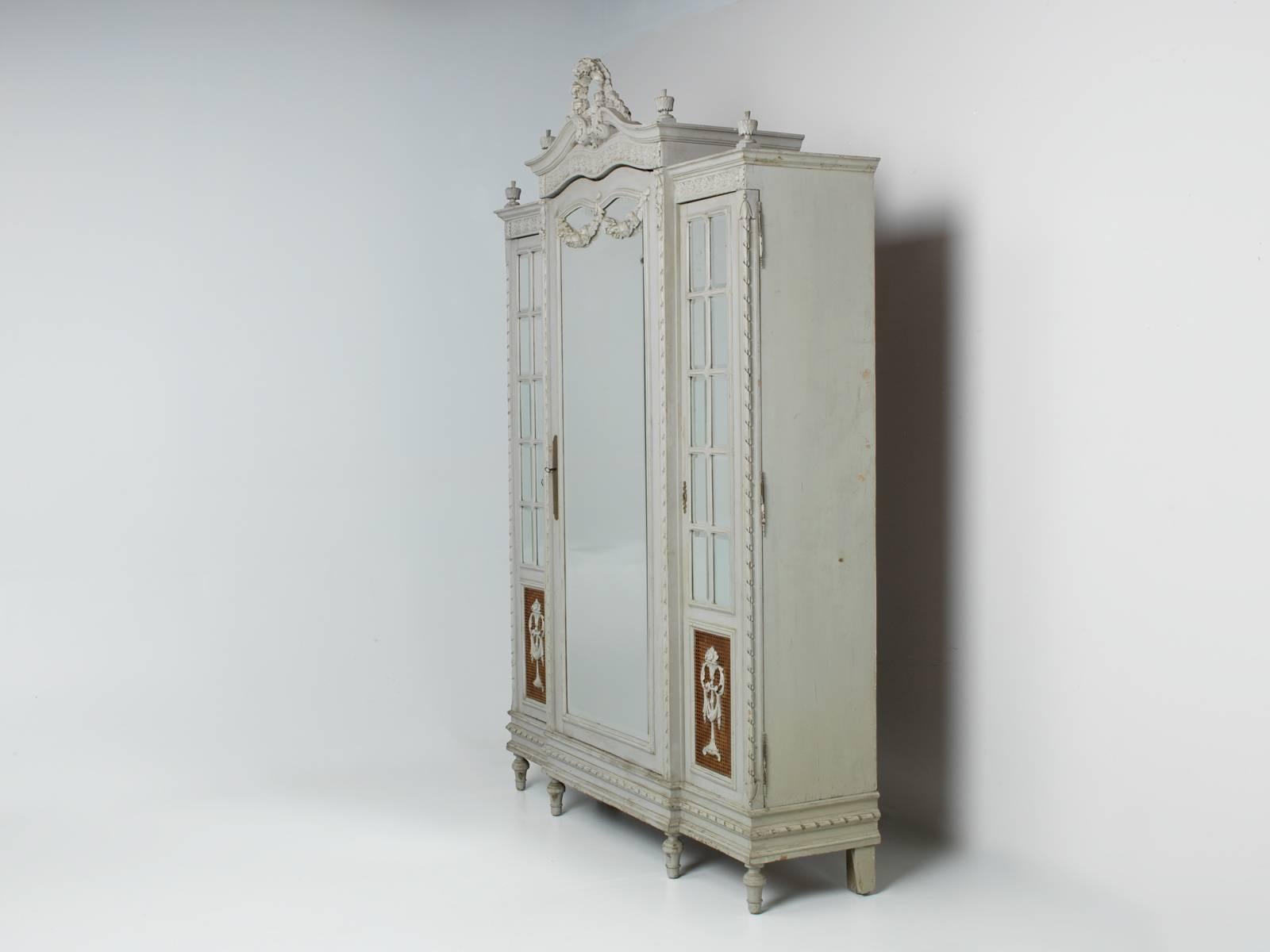 Antique French armoire, that is part of an extensive bedroom suite, that includes a matching cane bed with nightstand, large cane painted bergere chair and a dressing table with matching Louis XVI style bench. We are offering the items individually