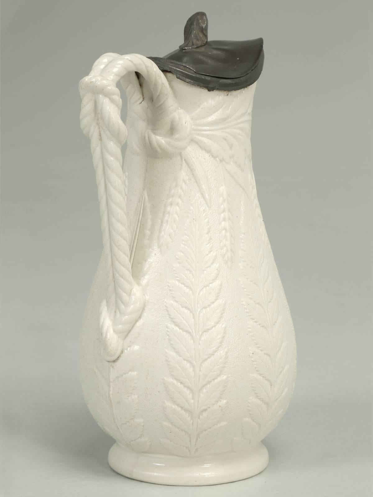 Antique English Staffordshire Fern-Leaf relief pitcher with applied rope handle and unusual weighted lid. We believe it was produced in 1848. There are no visual flaws or any evidence of prior repairs.