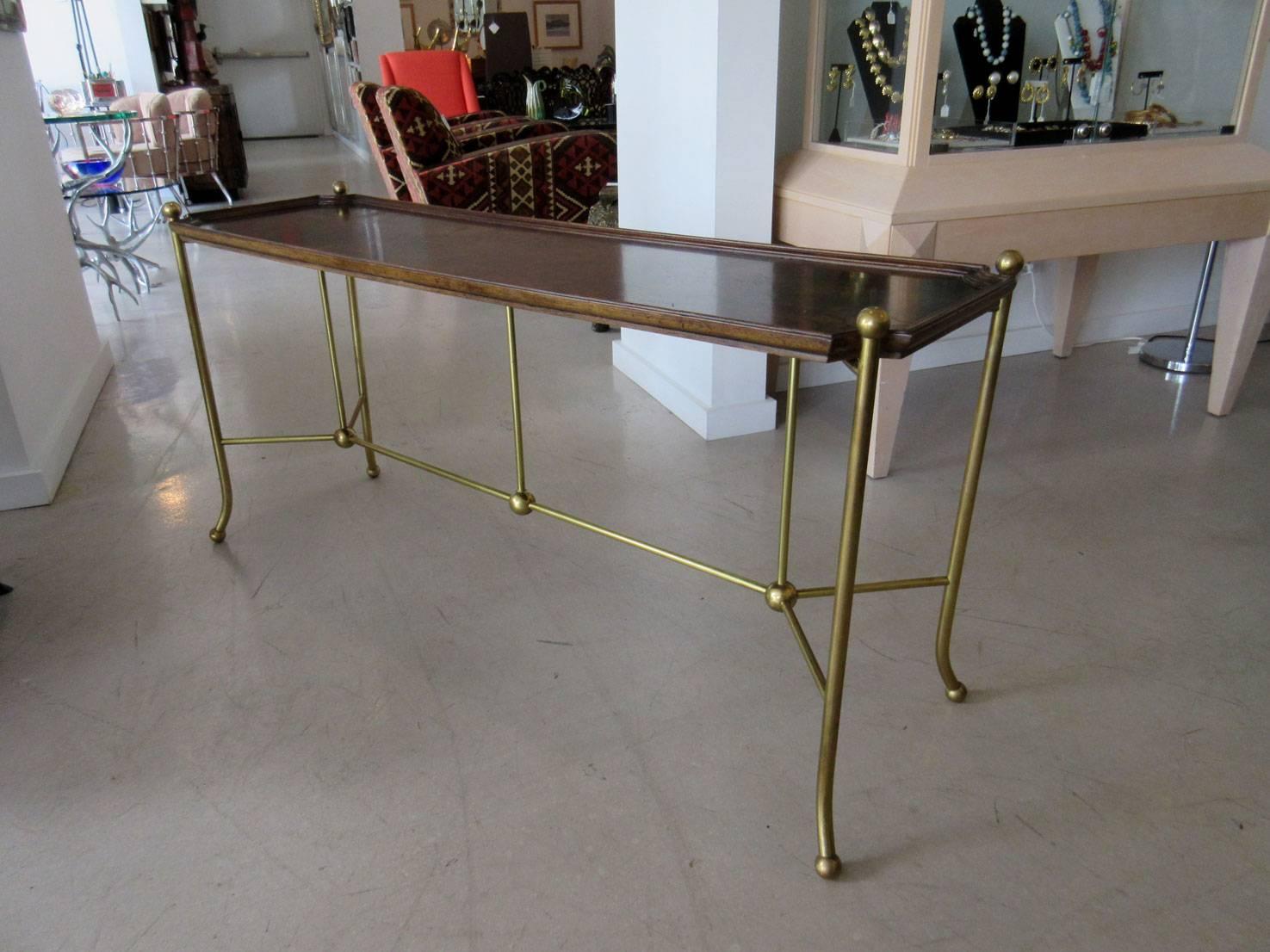 Vintage William Doezema for Mastercraft console table. The console is a dramatic combination of deep burl wood and simple brass hardware punctuated by brass balls.